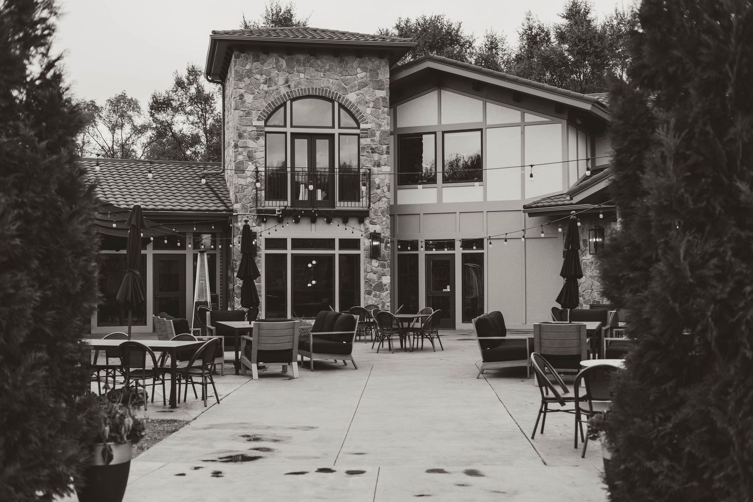A series of monochrome exterior views showing a historic building with outdoor seating and architectural details.