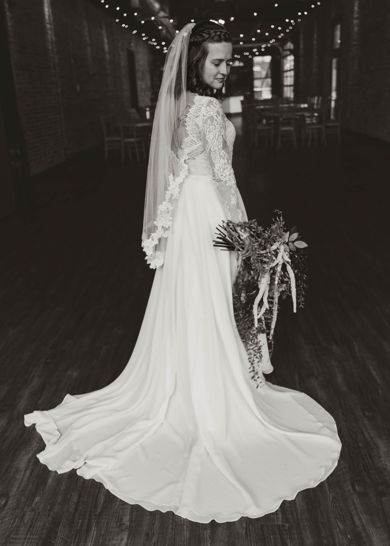 Wedding dress twirling sequence showing flowing white gown with string lights in dark venue.