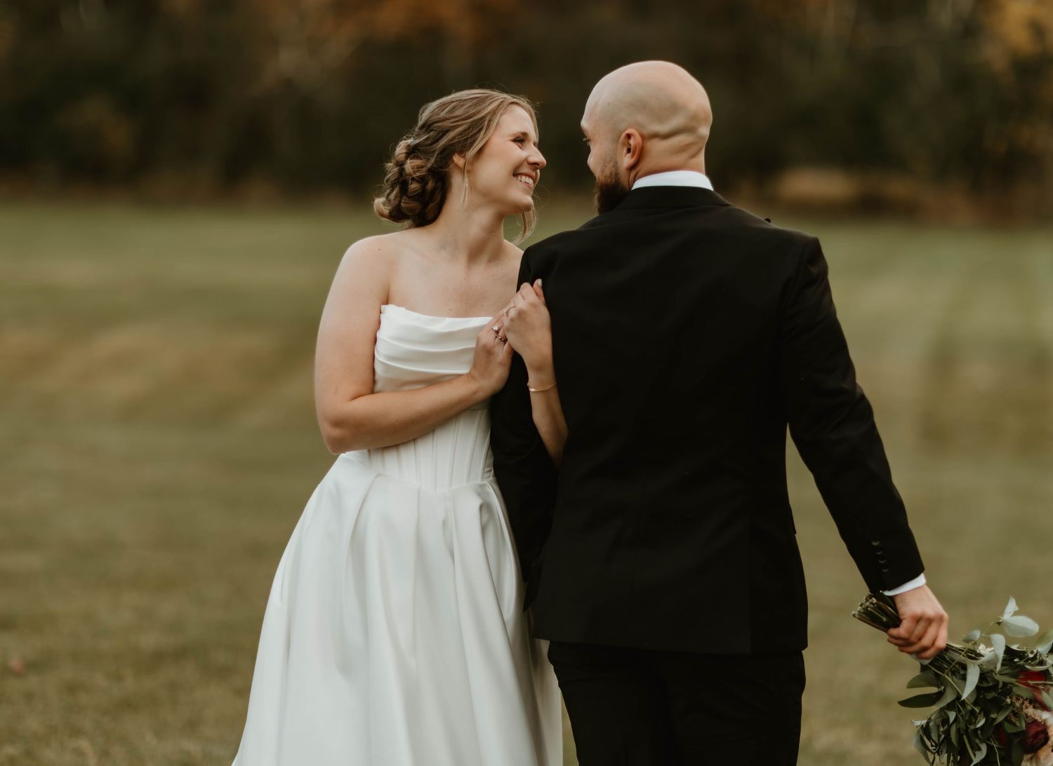Wedding couple shares an intimate moment against a backdrop of fall colors.