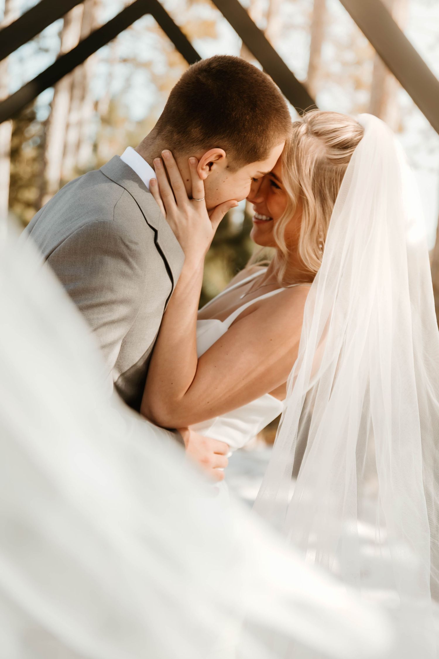 Intimate winter wedding portrait with flowing veil in soft natural light.