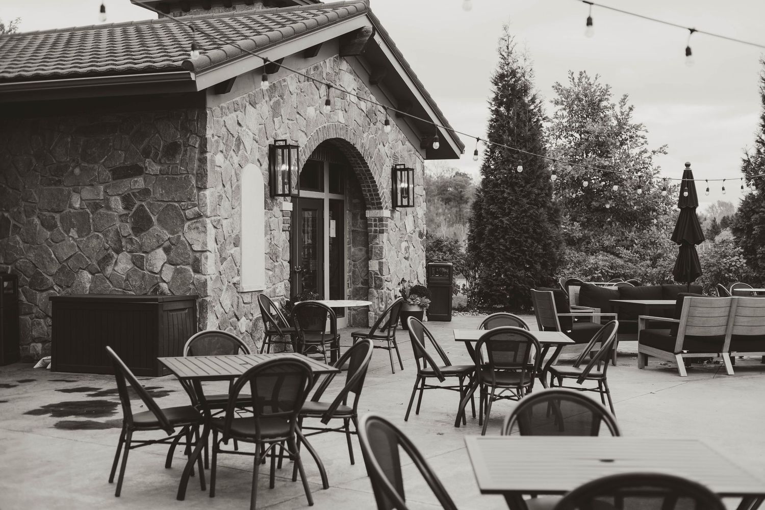 Rustic outdoor venue with stone walls and string lights creating an intimate setting.