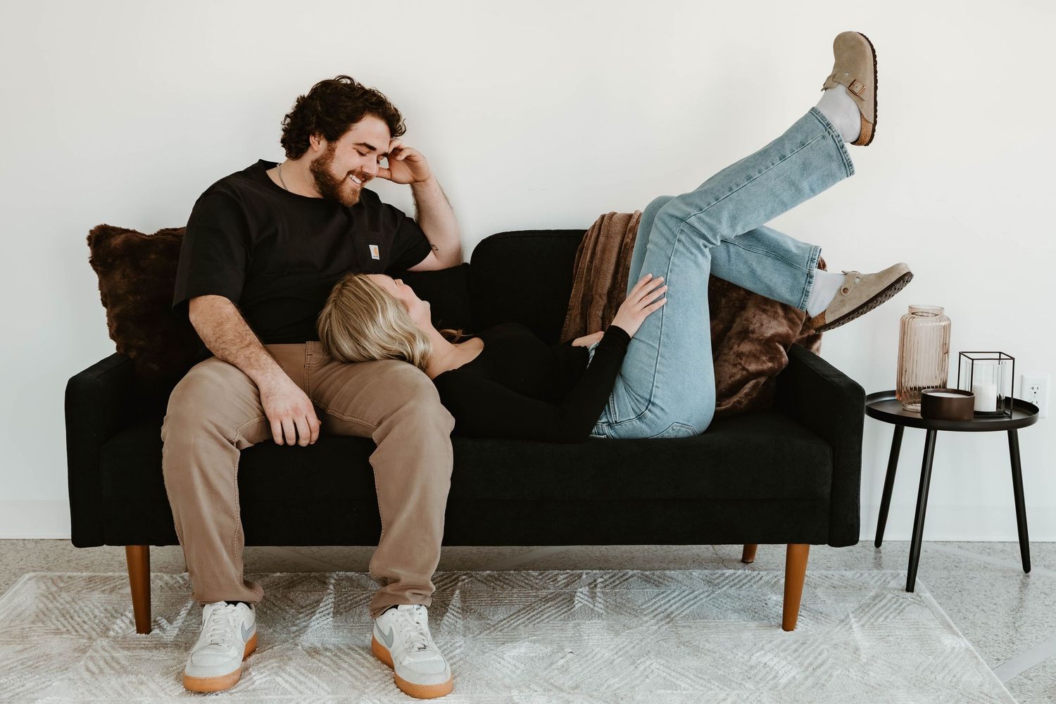 A series of connected photos showing someone sitting on a black couch with a small dog in various relaxed poses.