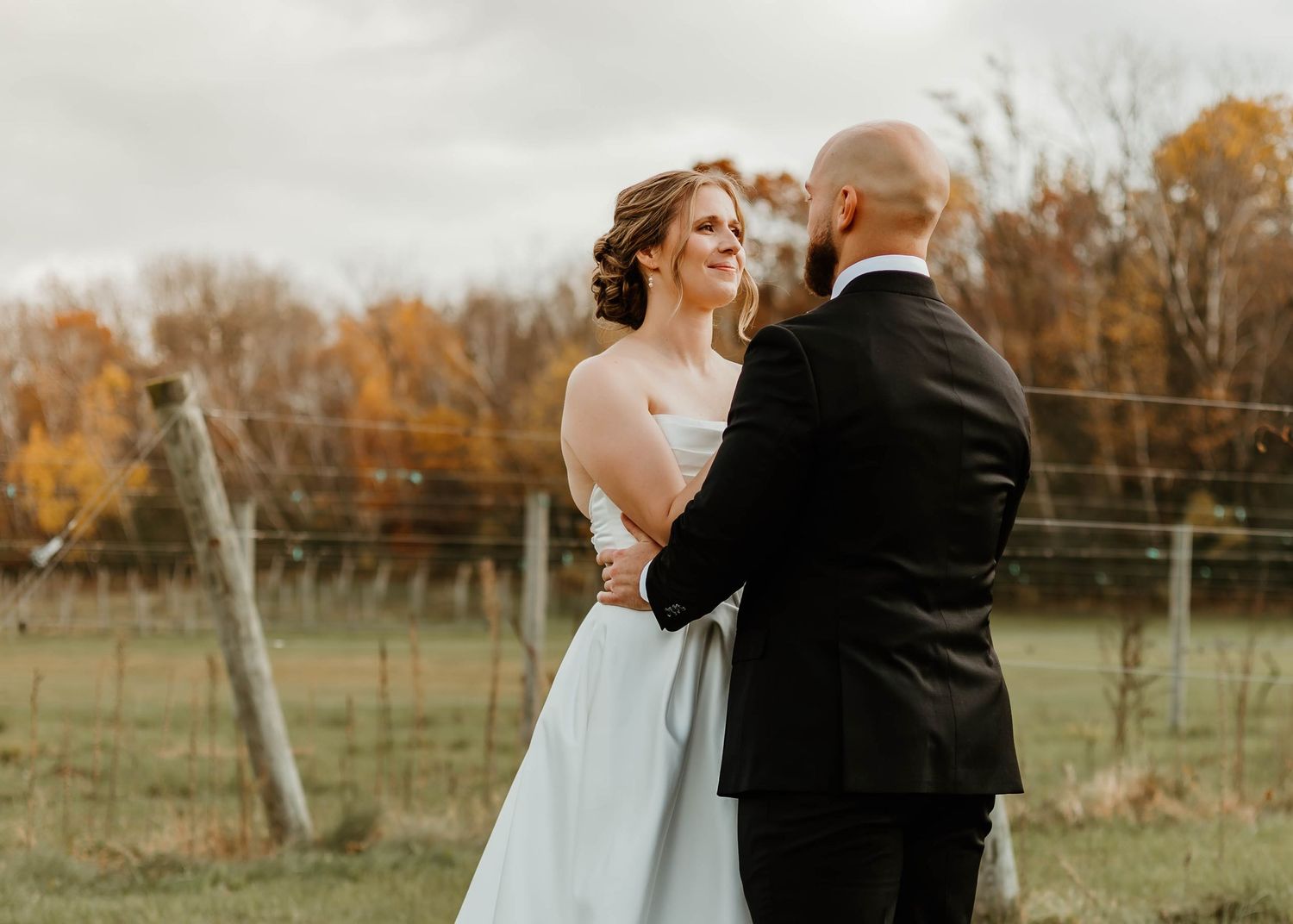 A tender wedding moment captured in a vineyard during autumn.