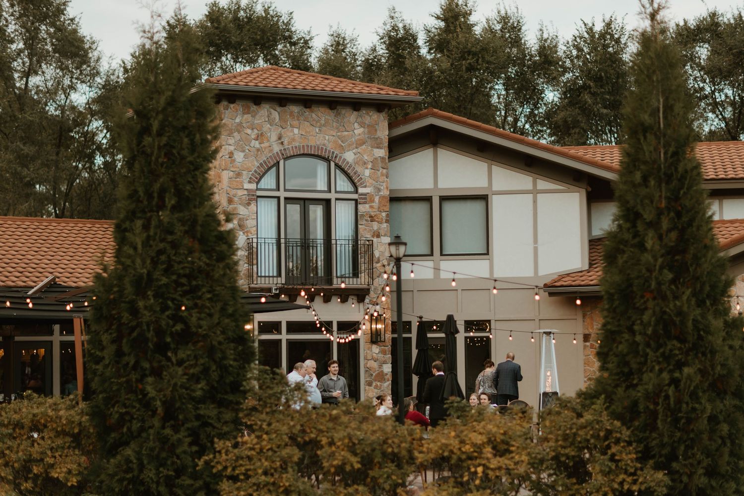 Exterior view of a modern winery building with stone accents and terracotta roof.