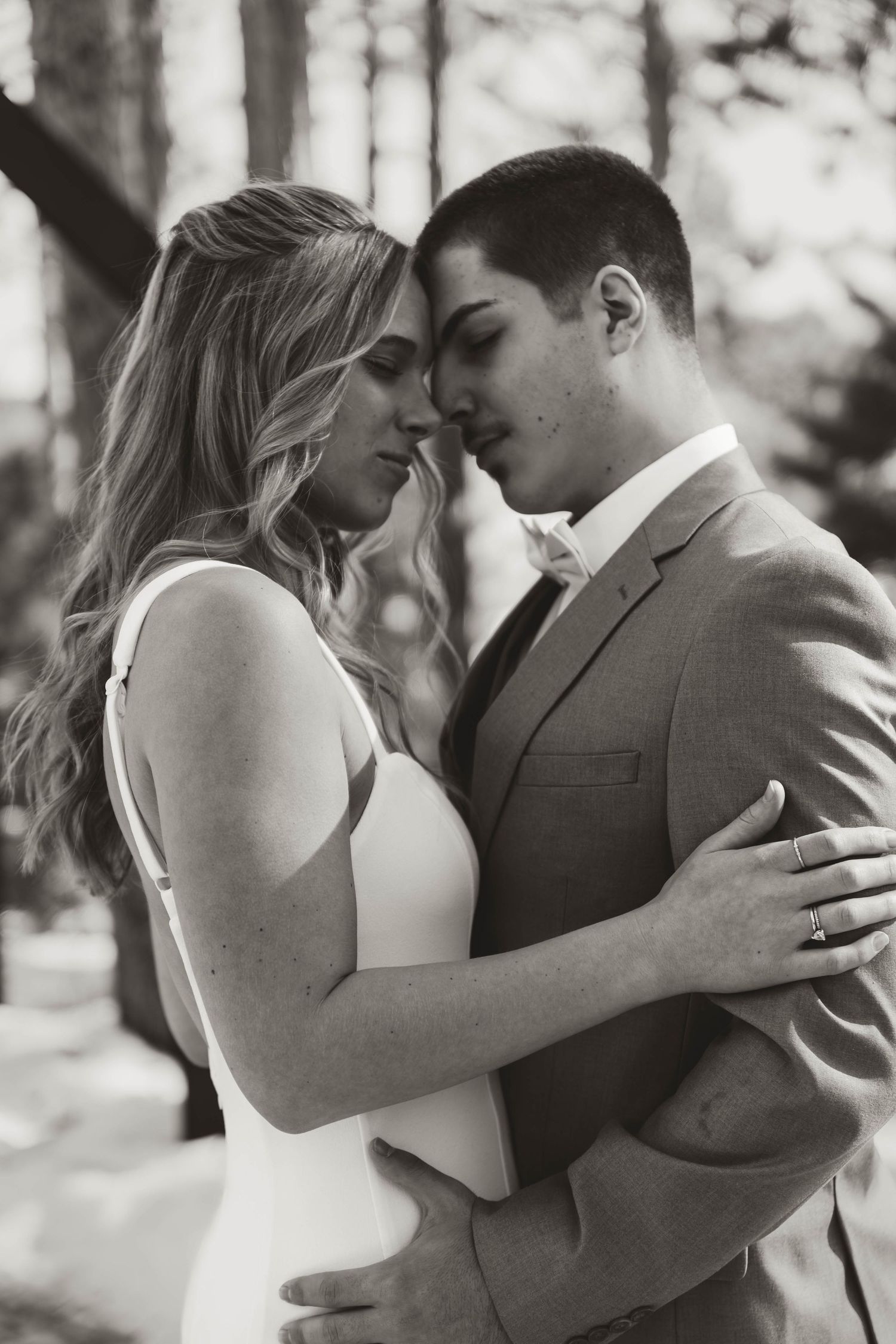 Intimate black and white portrait of newlyweds sharing tender moment.