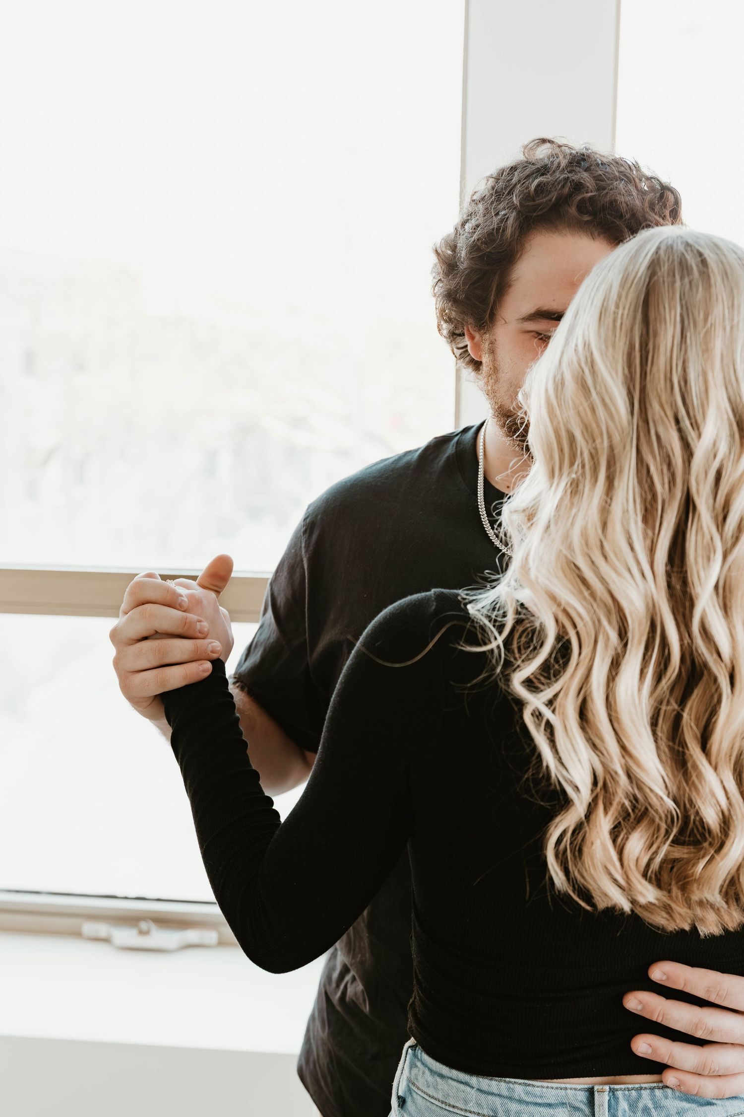 Romantic couple embracing in a bright minimalist room shown in multiple sequential photos.