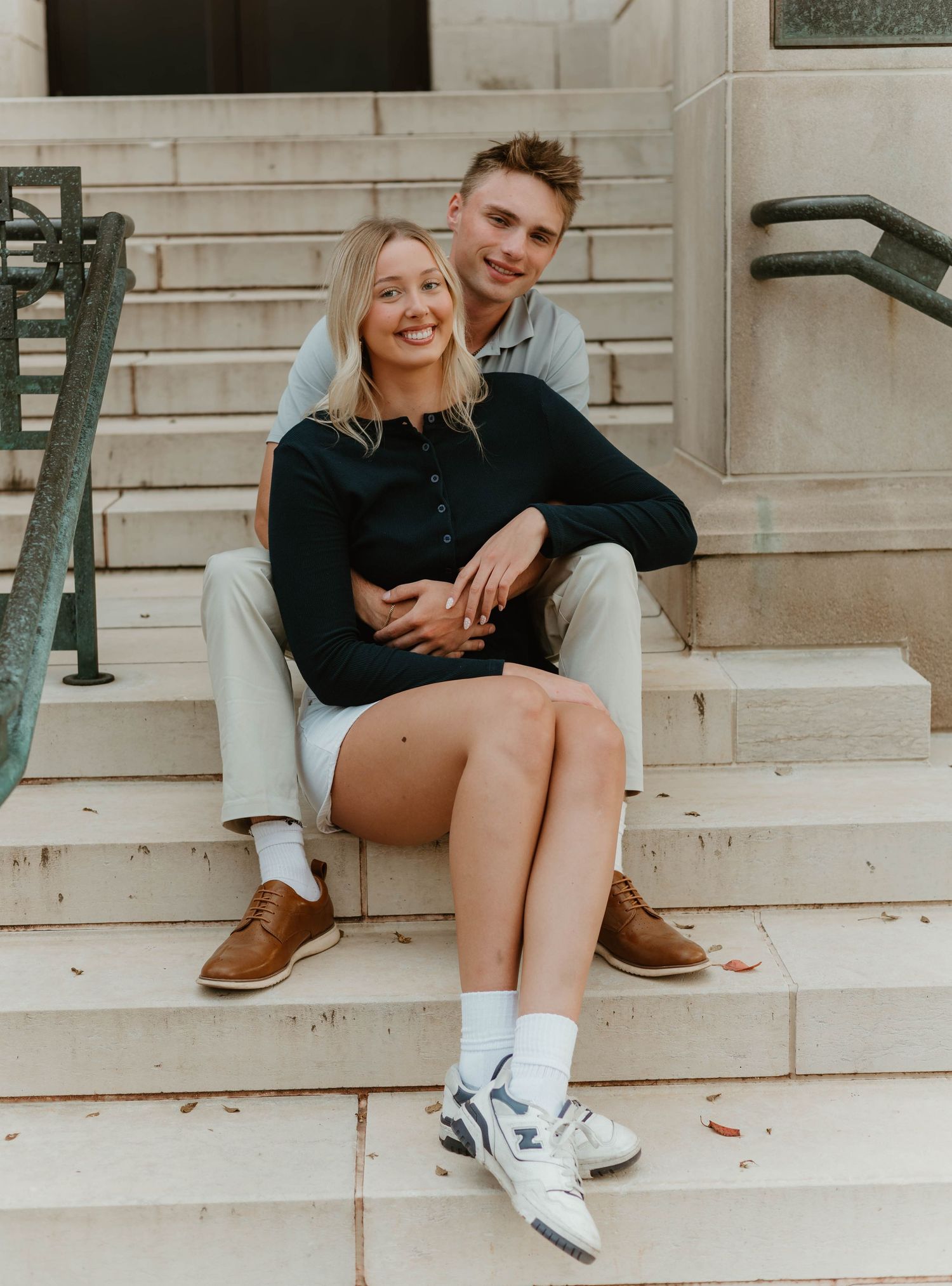 Casual lifestyle photoshoot on urban steps showing playful interaction and contrasting footwear.