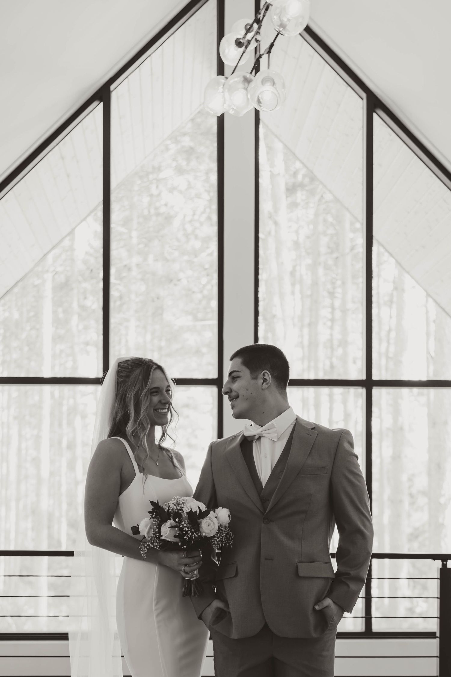 Wedding couple sharing intimate moments in a modern chapel with geometric windows and natural light.