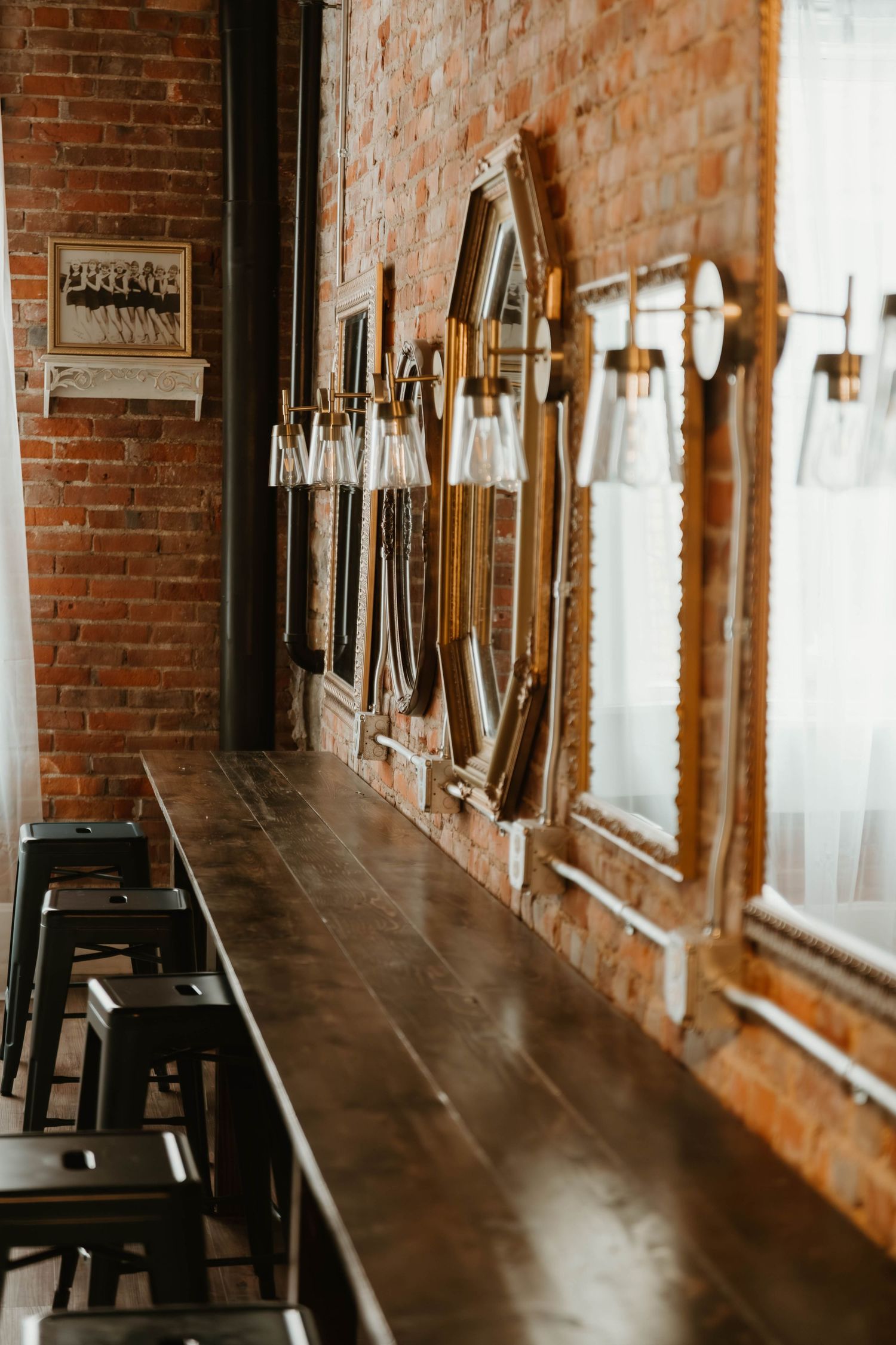 Industrial chic bar interior with exposed brick walls and hanging pendant lights.