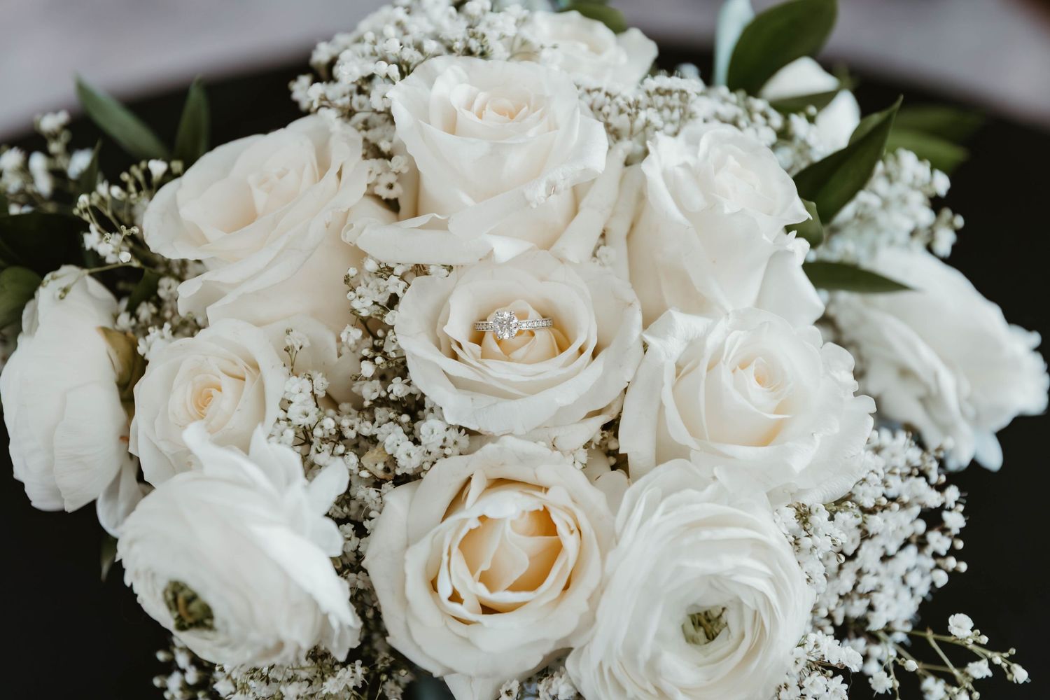 Elegant white roses and baby's breath floral arrangement with delicate petals and green foliage creates a romantic display.