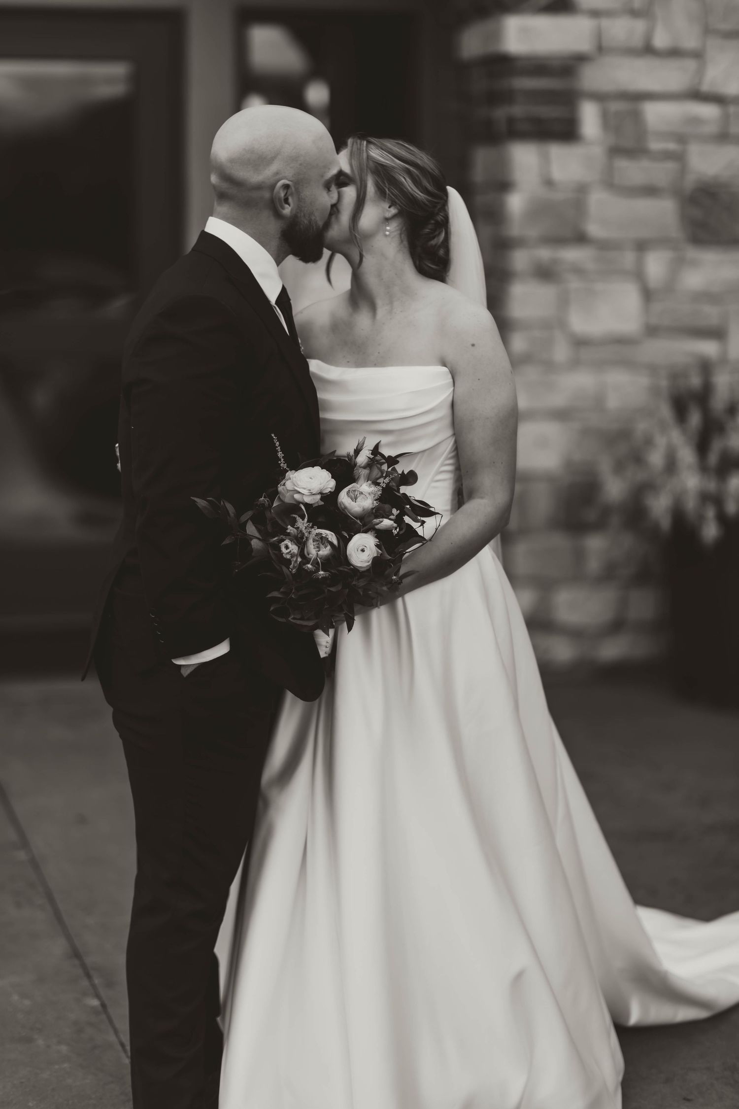 Black and white wedding portrait capturing intimate moments between newlyweds.