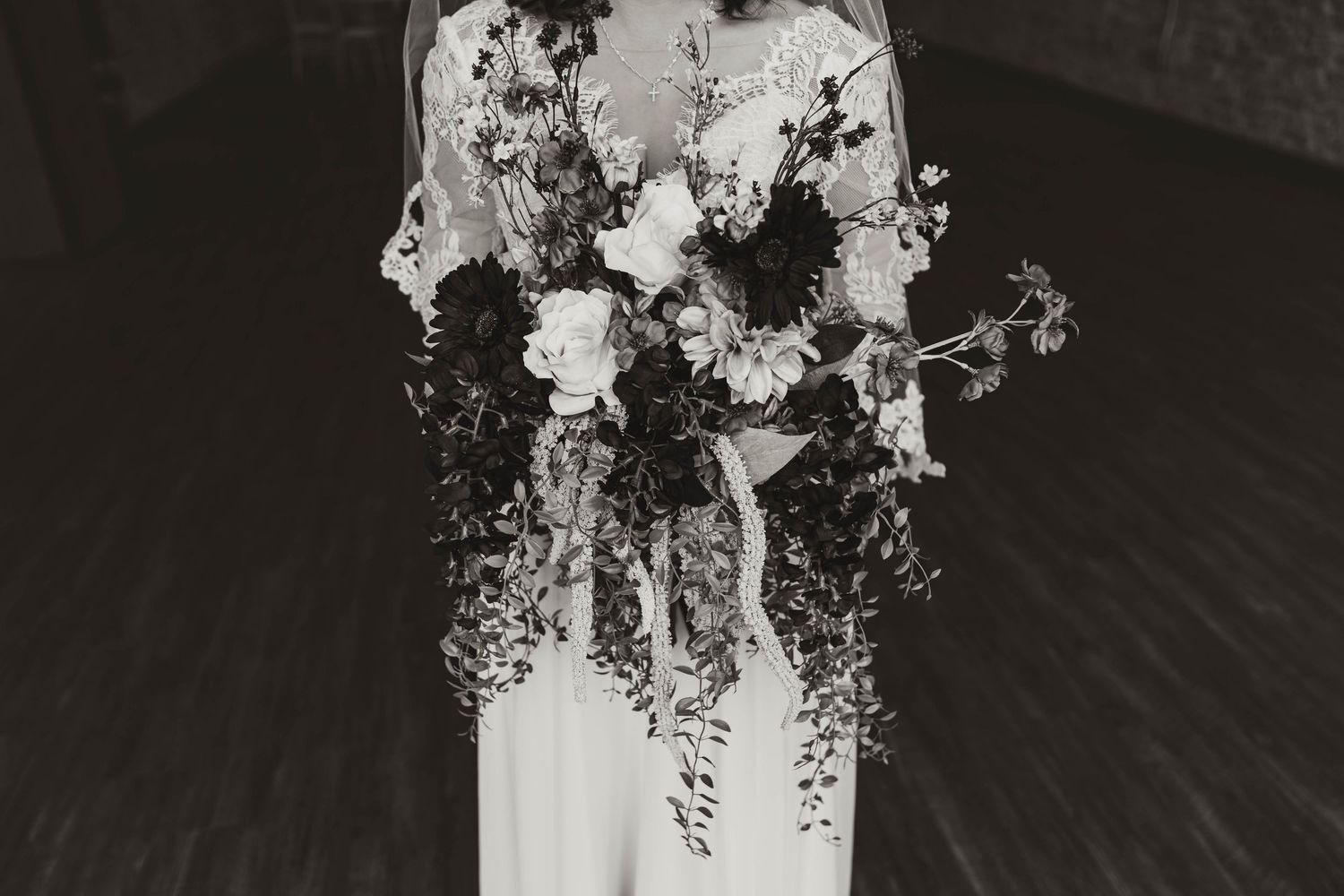 Black and white photo of an elegant cascading wedding bouquet with mixed flowers.