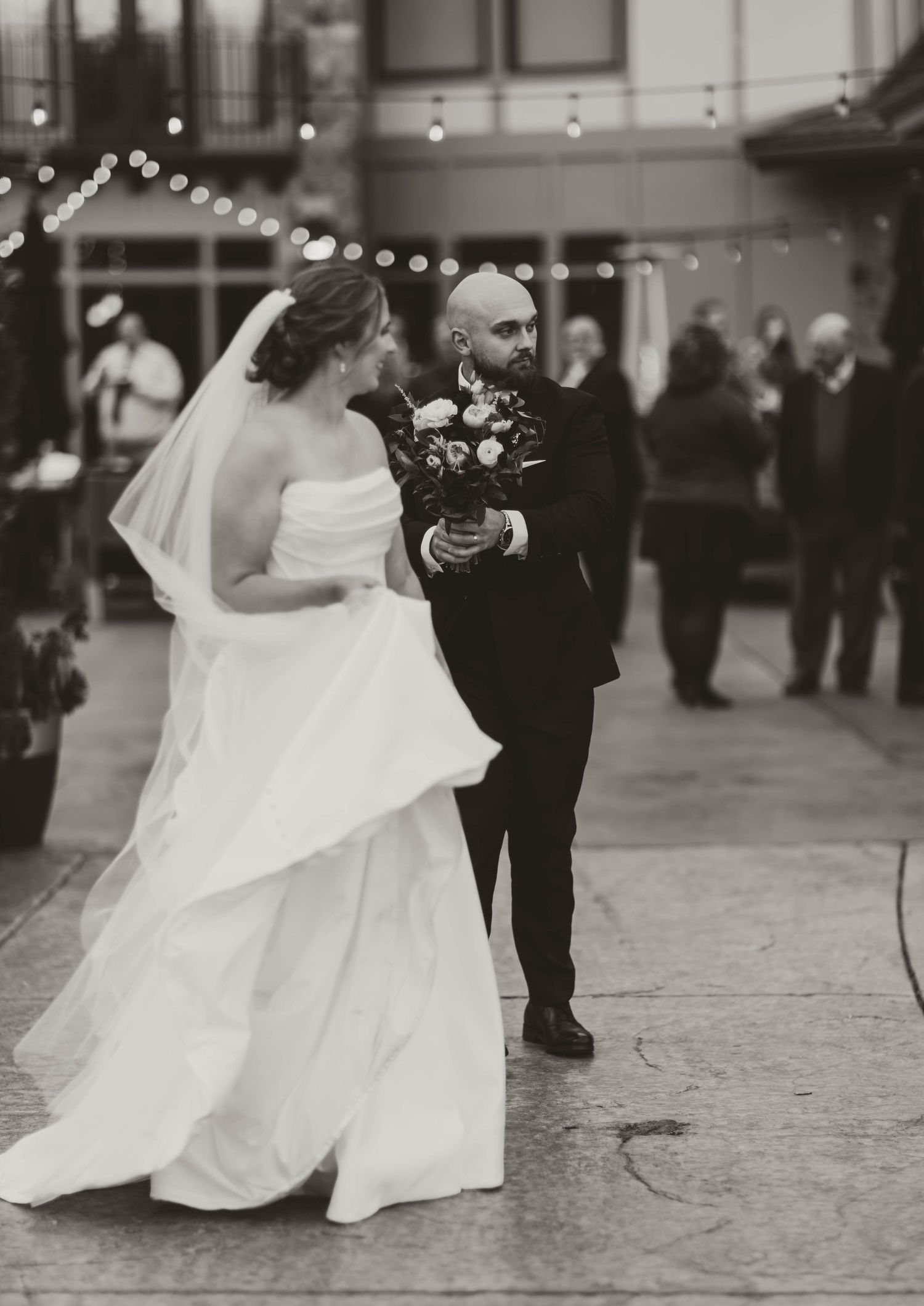 A black and white wedding photograph series showing a couple dancing with the bride's white dress flowing elegantly.