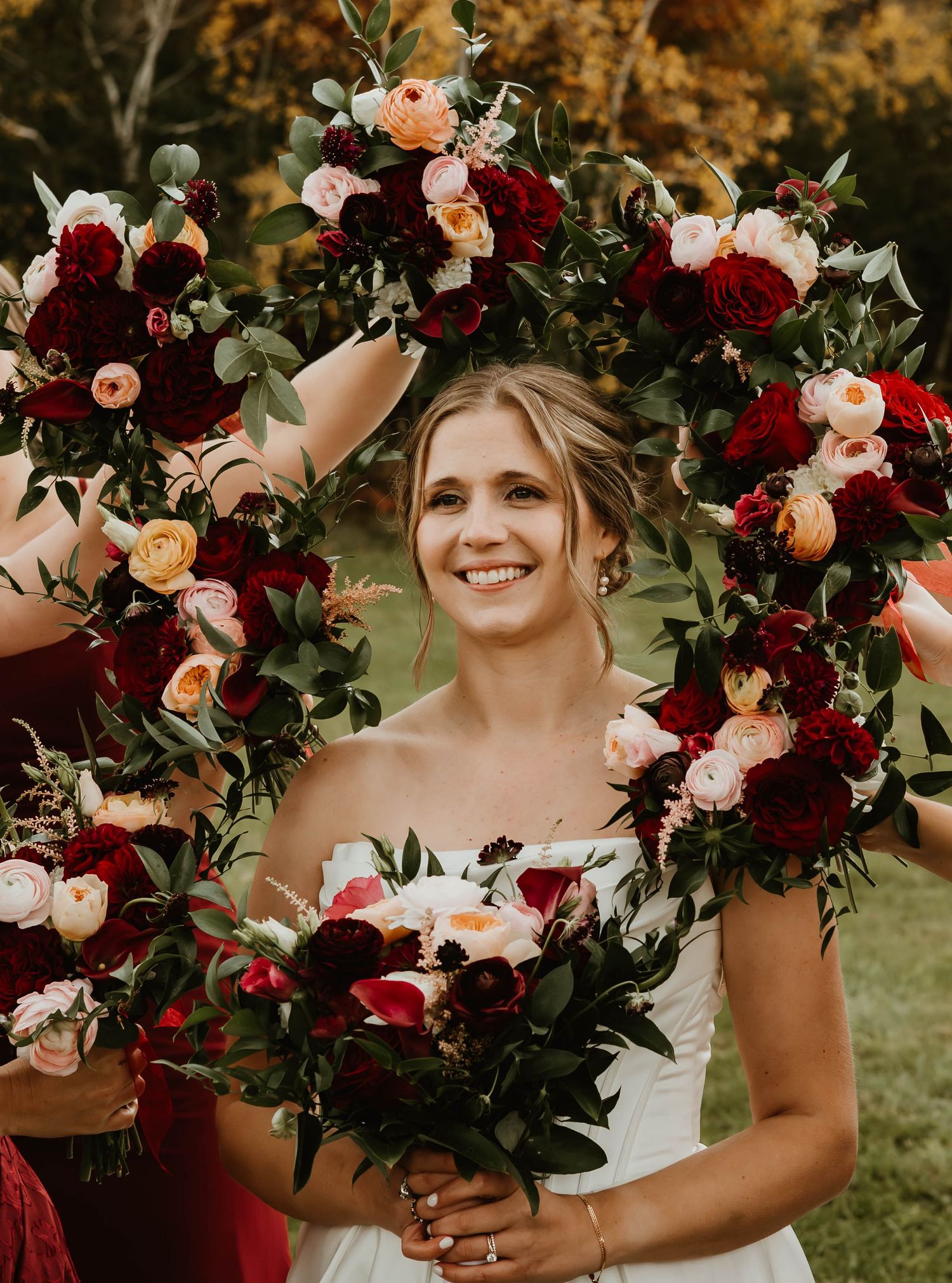 Stunning wedding bouquet featuring deep red and blush roses with lush greenery.