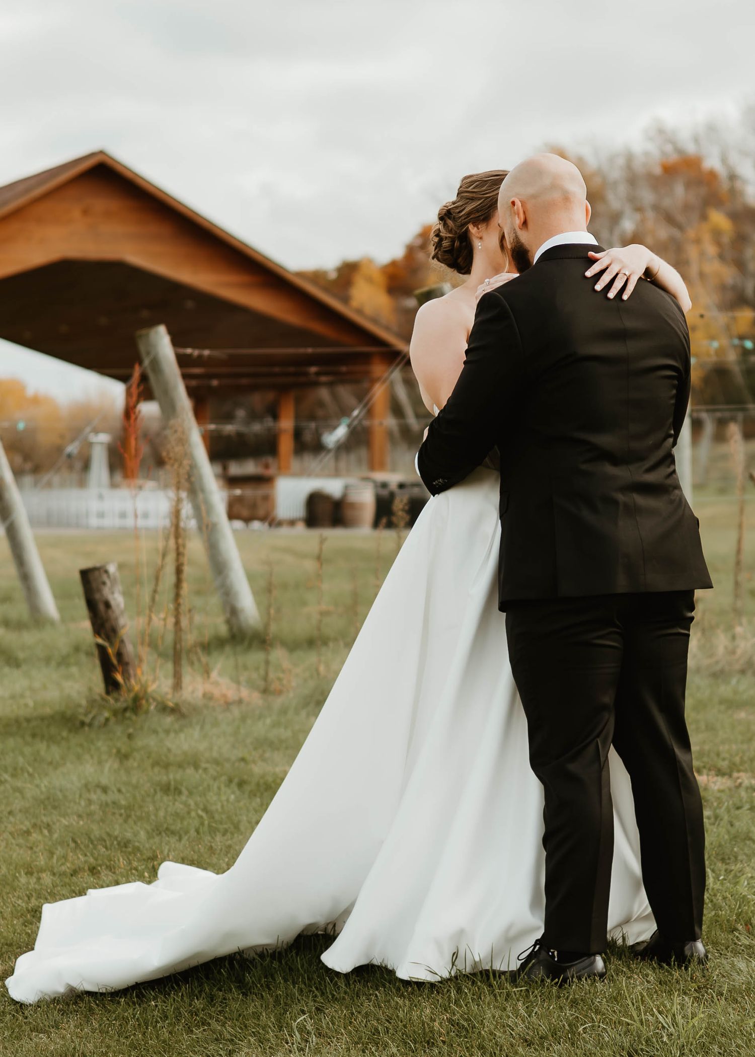 A series of romantic wedding photos showing a couple in a white dress and black suit embracing in a rustic outdoor setting.