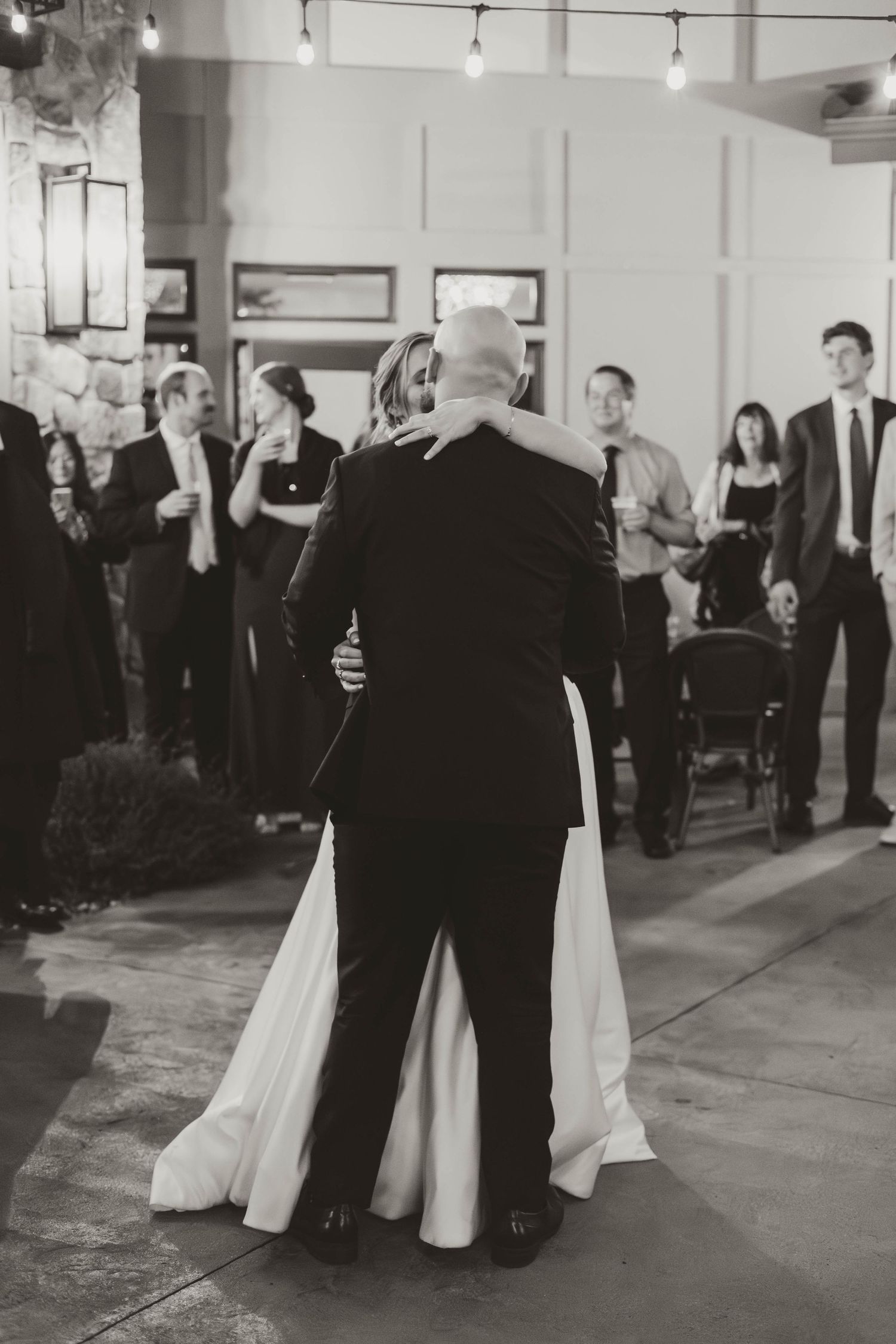 A couple shares their first dance in an elegantly lit reception venue.