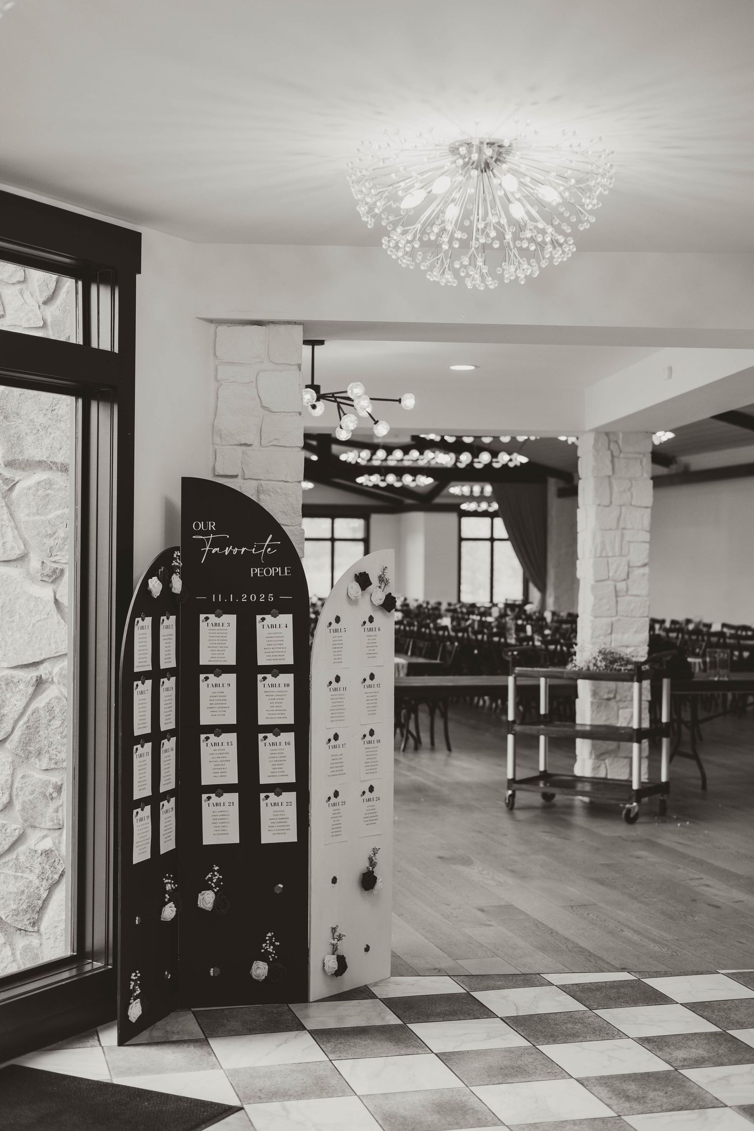 A modern dance studio interior with hardwood floors, black and white checkered tiles, and elegant crystal chandeliers.