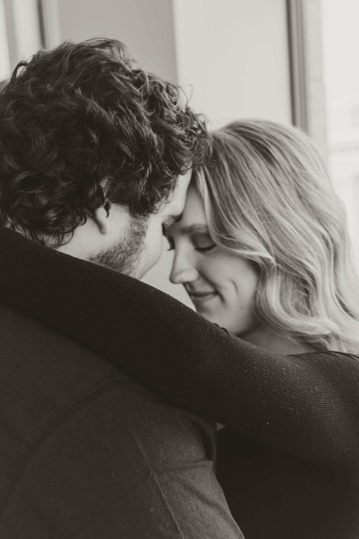 A romantic black and white photo series showing a couple in an intimate embrace and tender kiss.