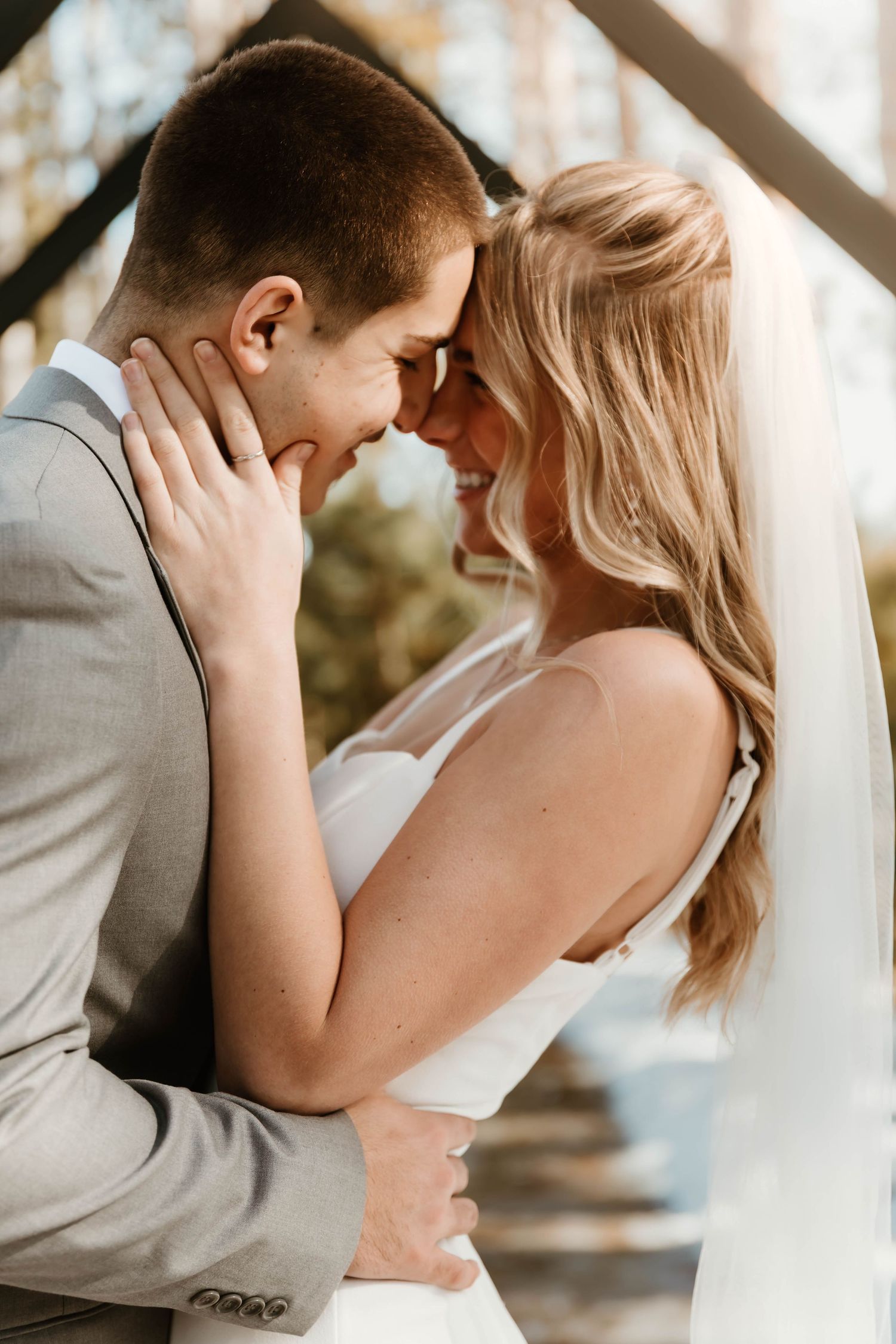 Romantic wedding moment captured under natural lighting with soft, intimate expressions.