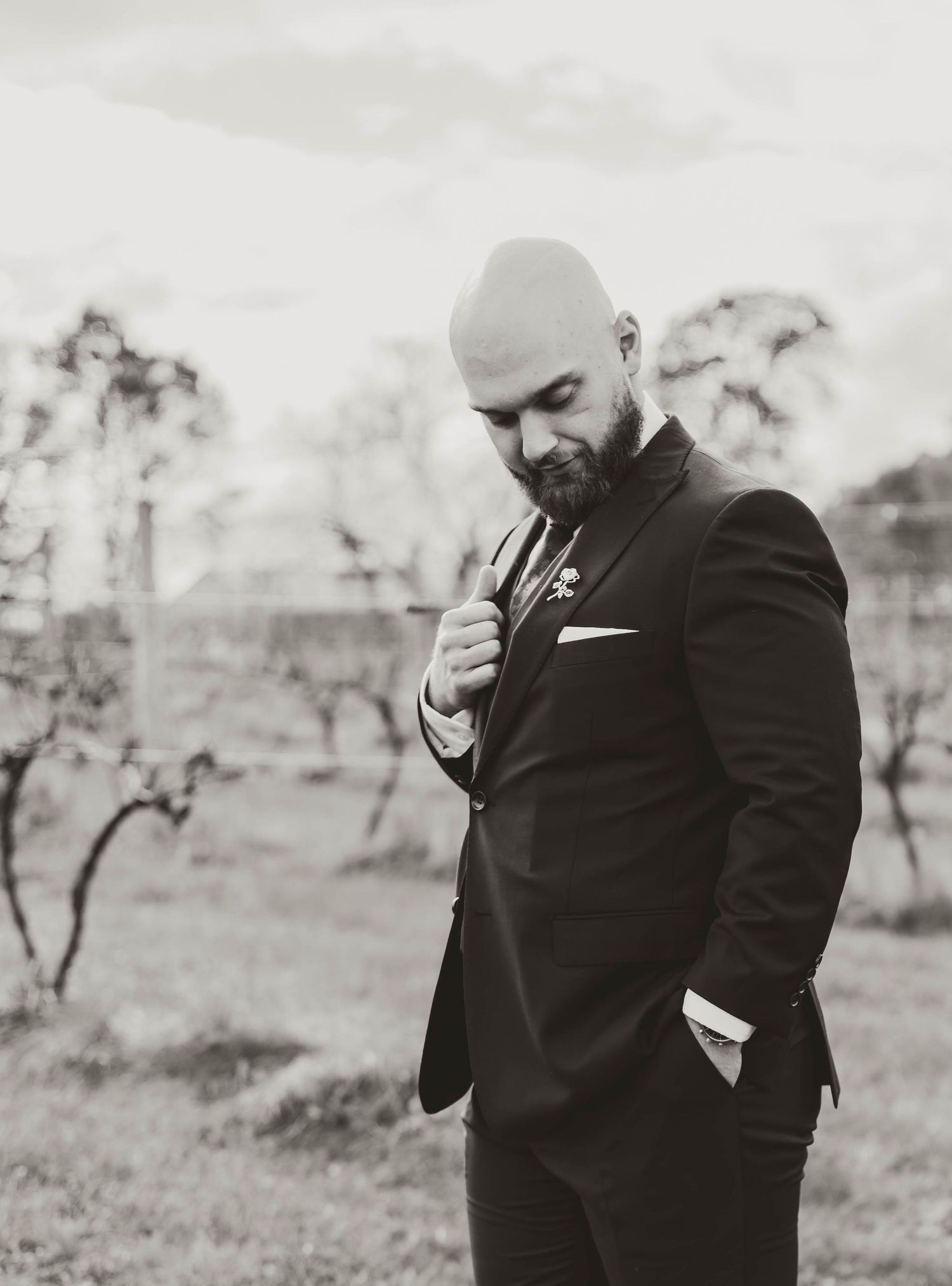 Emotional first look moment captured in black and white as groom wipes away tears during wedding ceremony.
