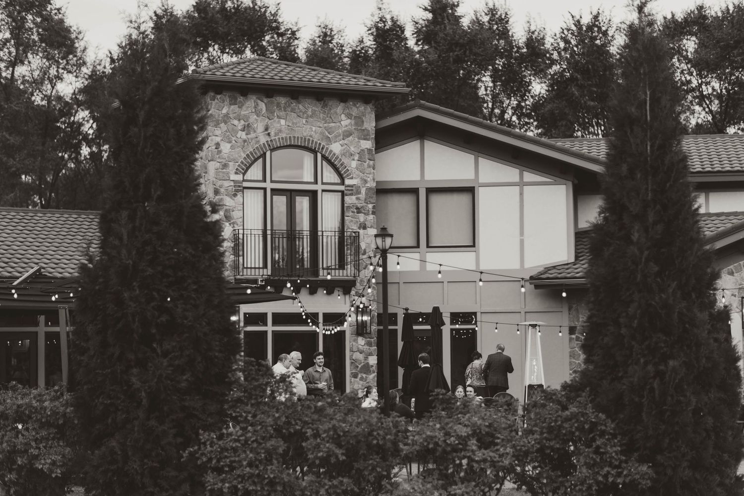 Panoramic view of a rustic winery building nestled among evergreen trees.