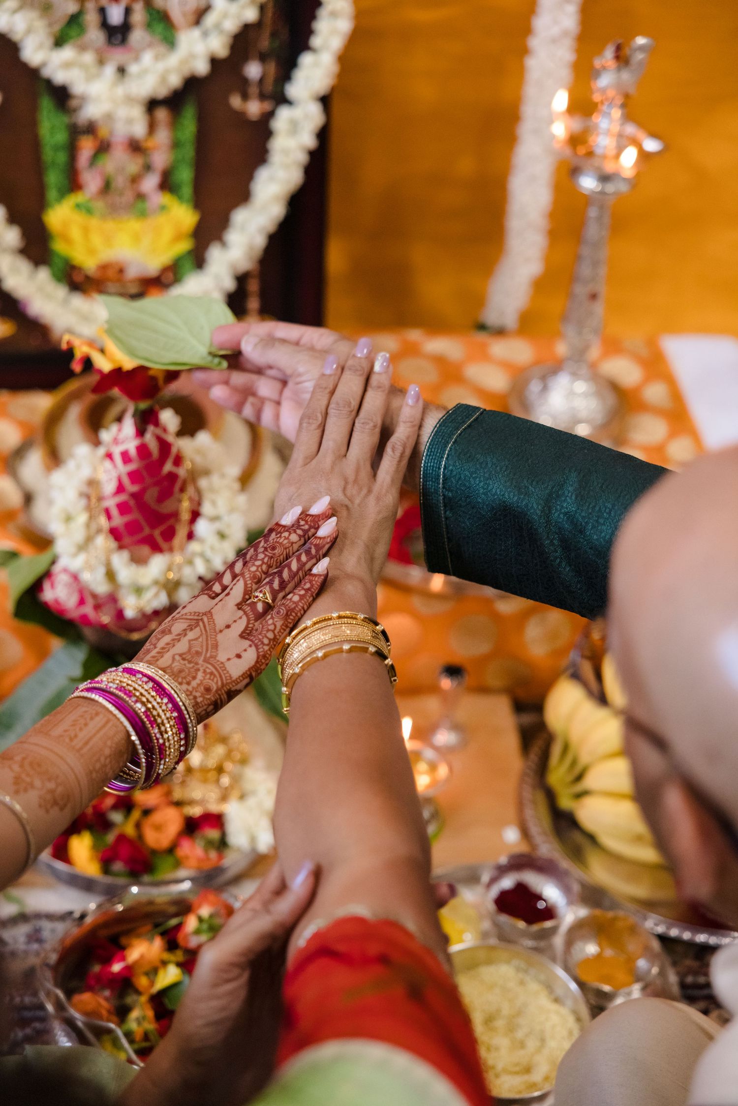 Traditional Hindu wedding ceremony with decorated hands performing ritual gestures.