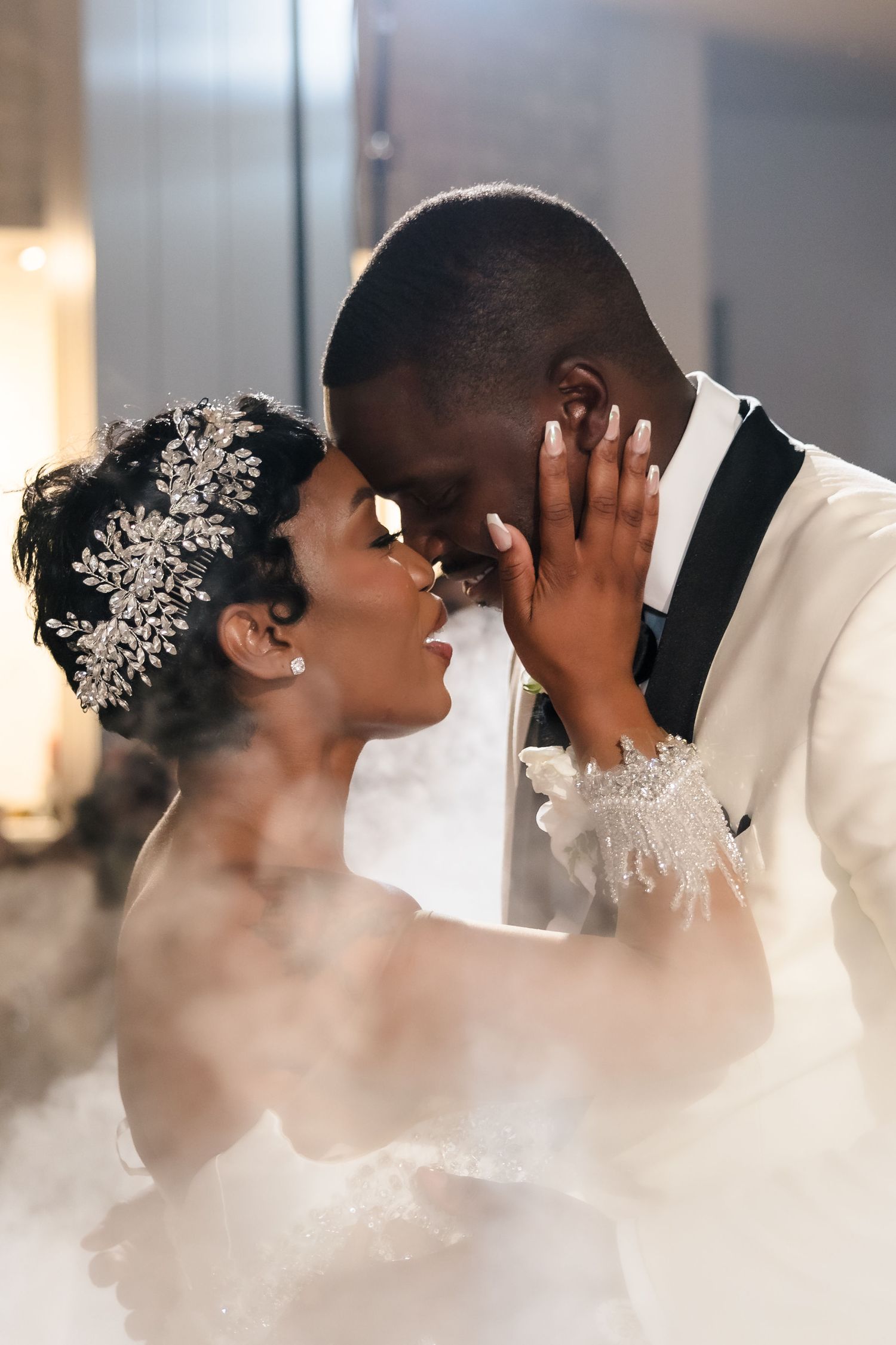 Intimate wedding moment captured in soft lighting with decorative hair accessories.