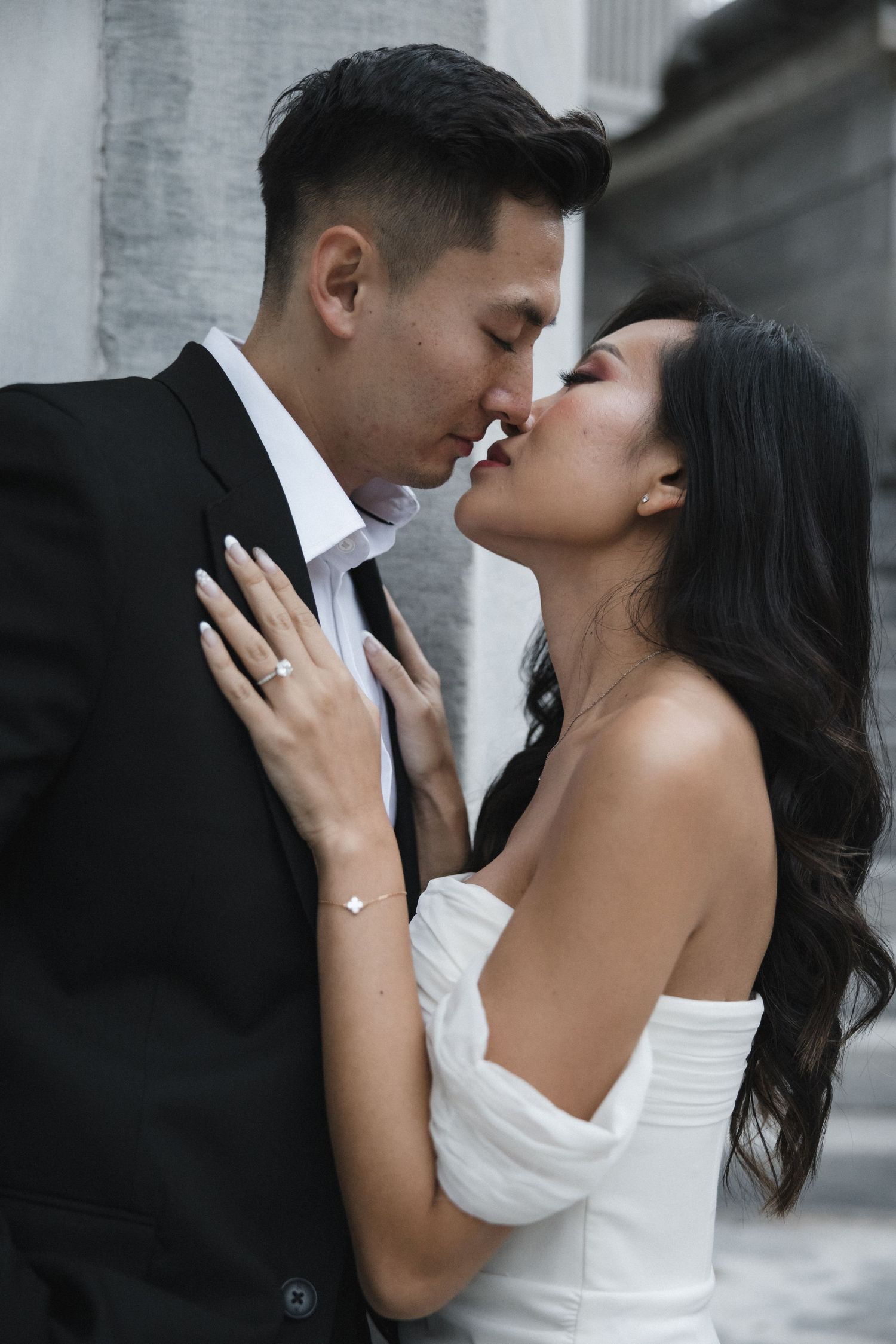 Intimate black and white portrait of a couple in elegant wedding attire.