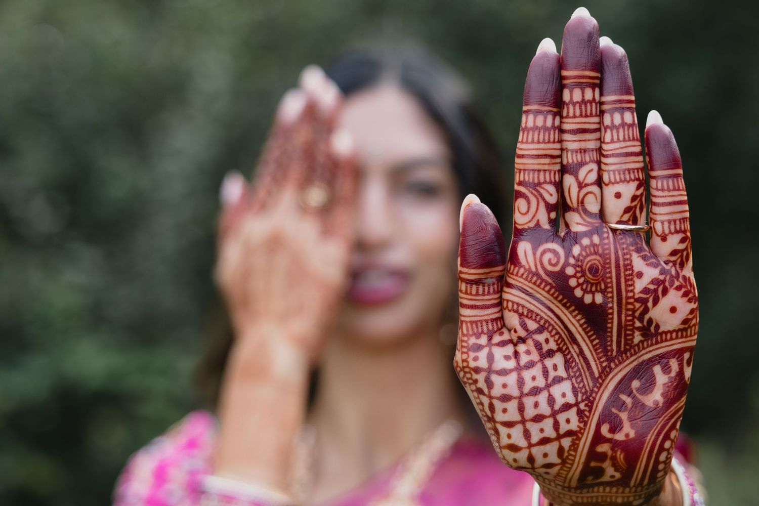 Detailed view of intricate henna designs on hands with traditional Indian jewelry.