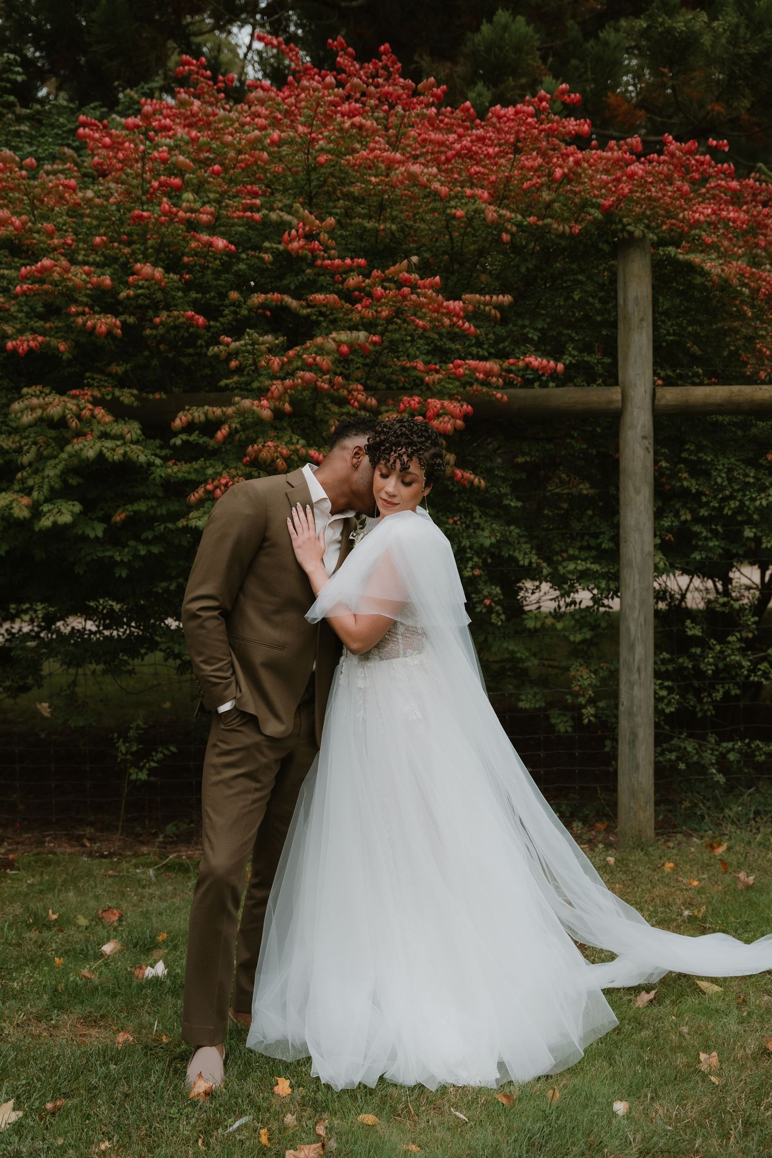 A romantic autumn wedding scene with red maple leaves and a flowing white dress.