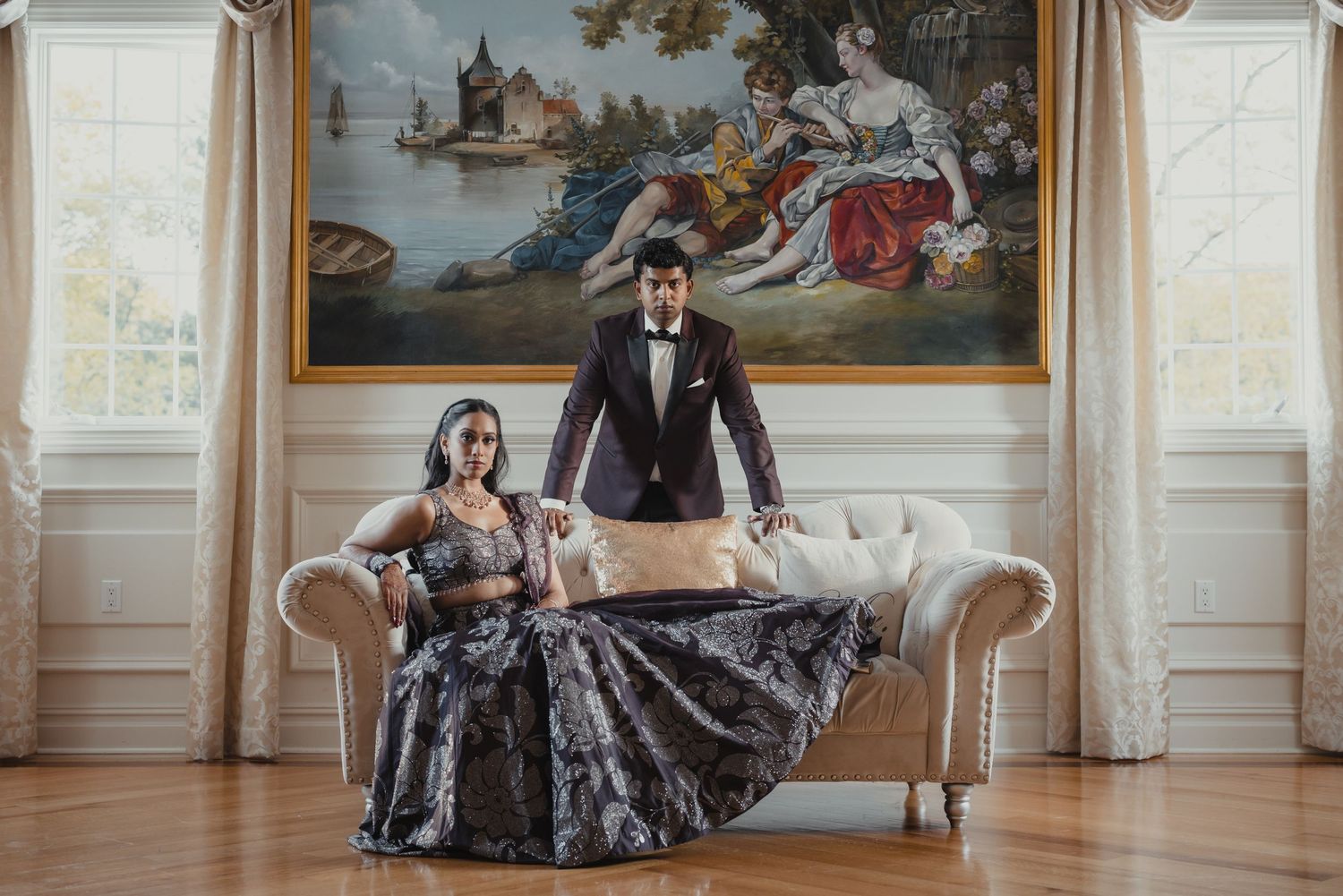 Wedding couple posing in an ornate vintage room with classical paintings and decor.