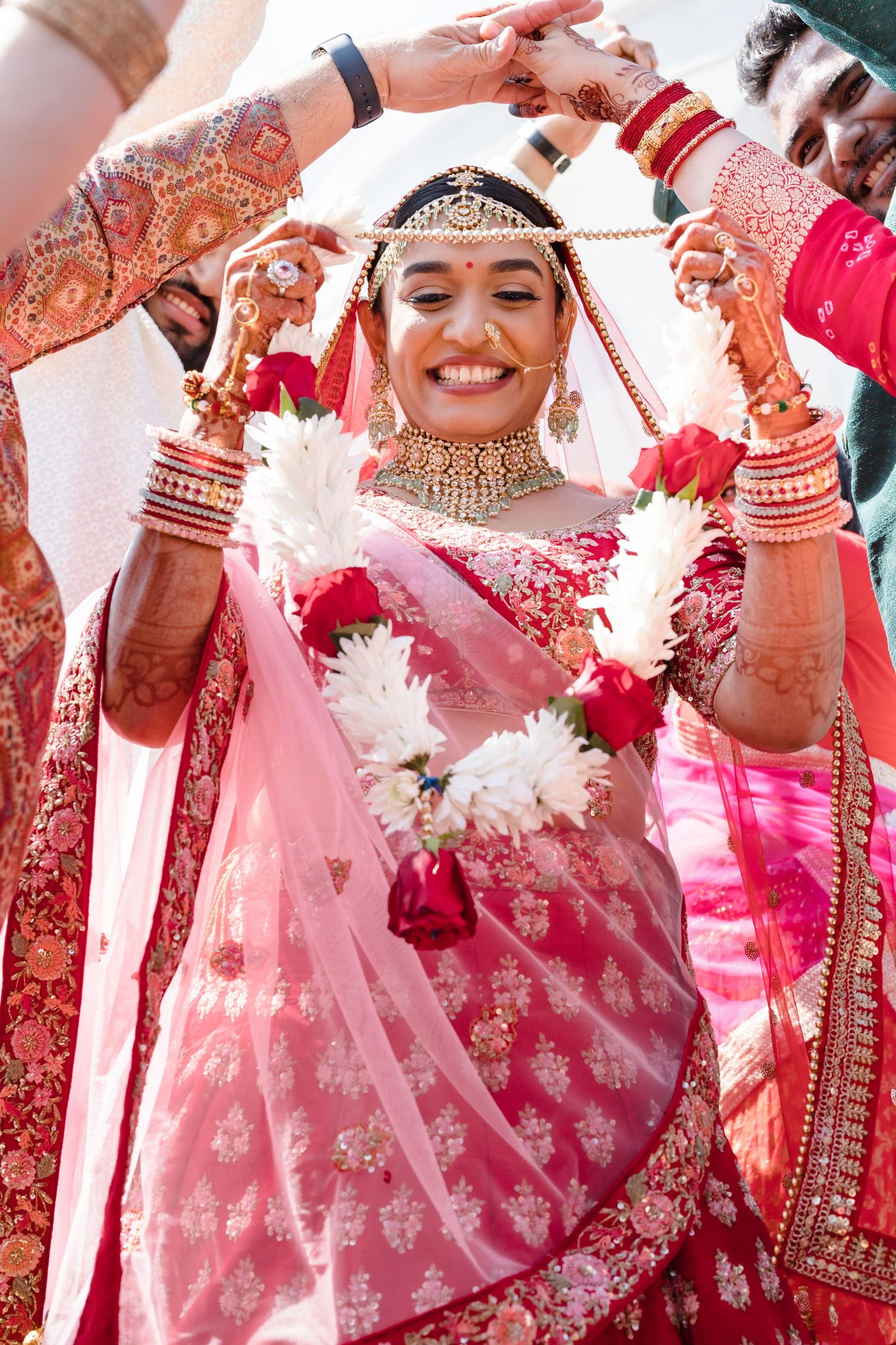 Festive celebration scene with traditional pink and red attire and decorative elements.