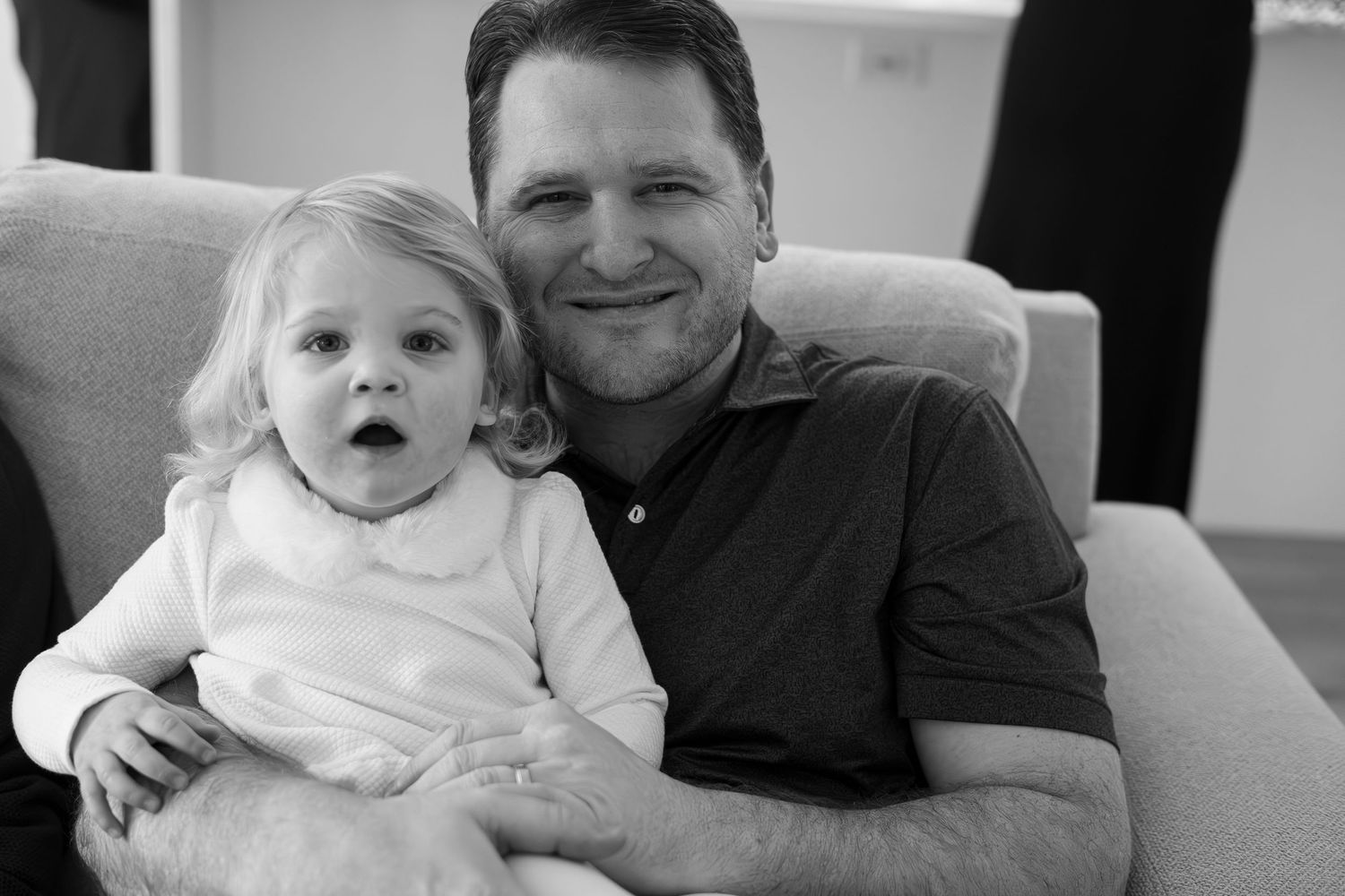 A series of black and white photos showing joyful family moments in white clothing.