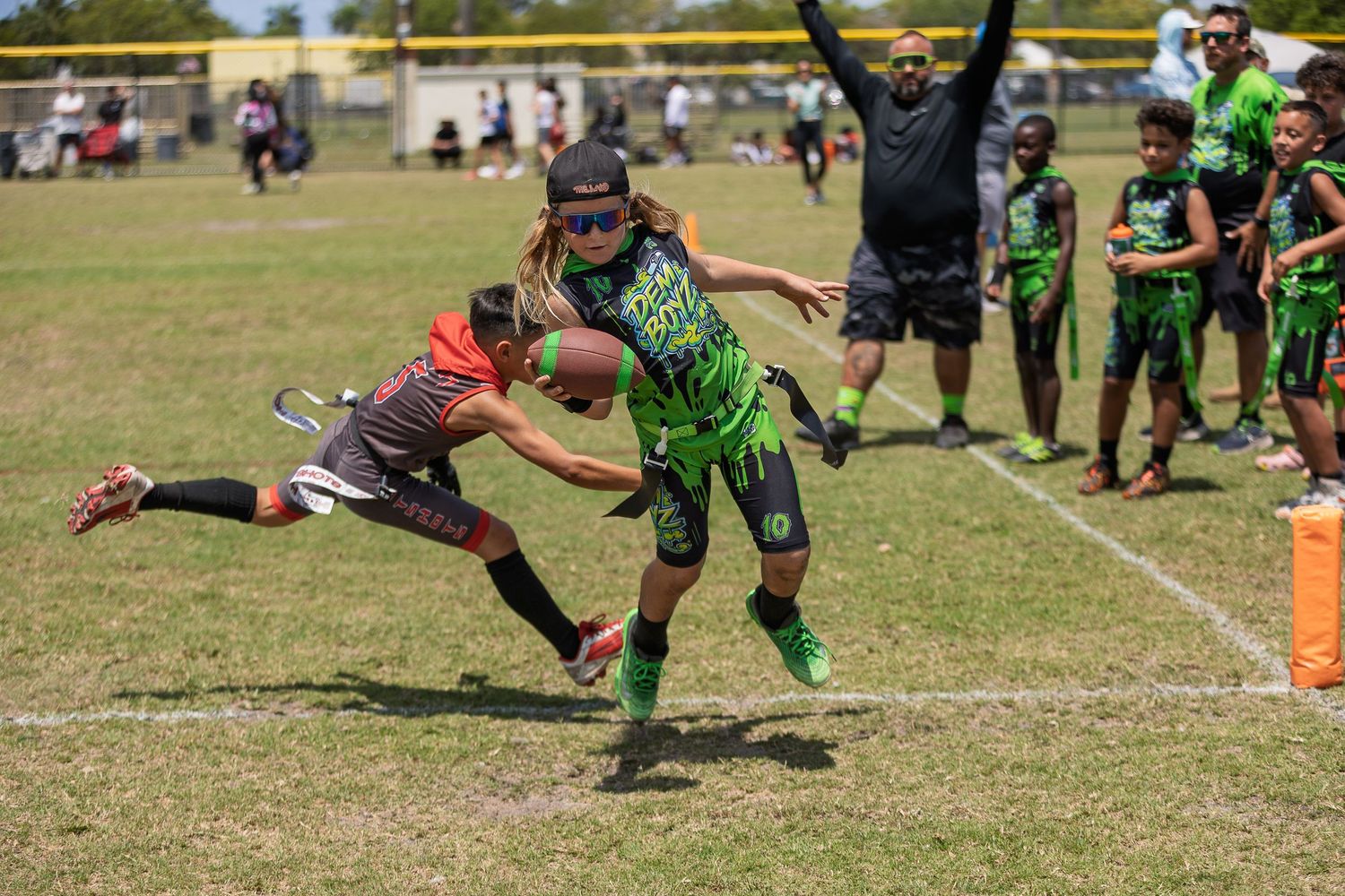 Action shots of youth football players jumping and diving for the ball during a game.