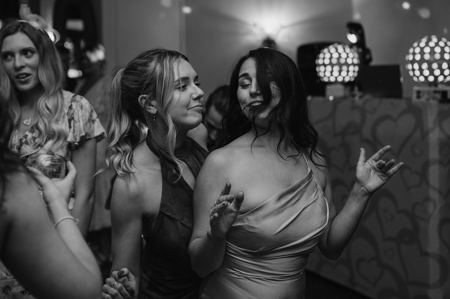 Dancing guests enjoying the nightclub atmosphere with disco balls glowing in the background.