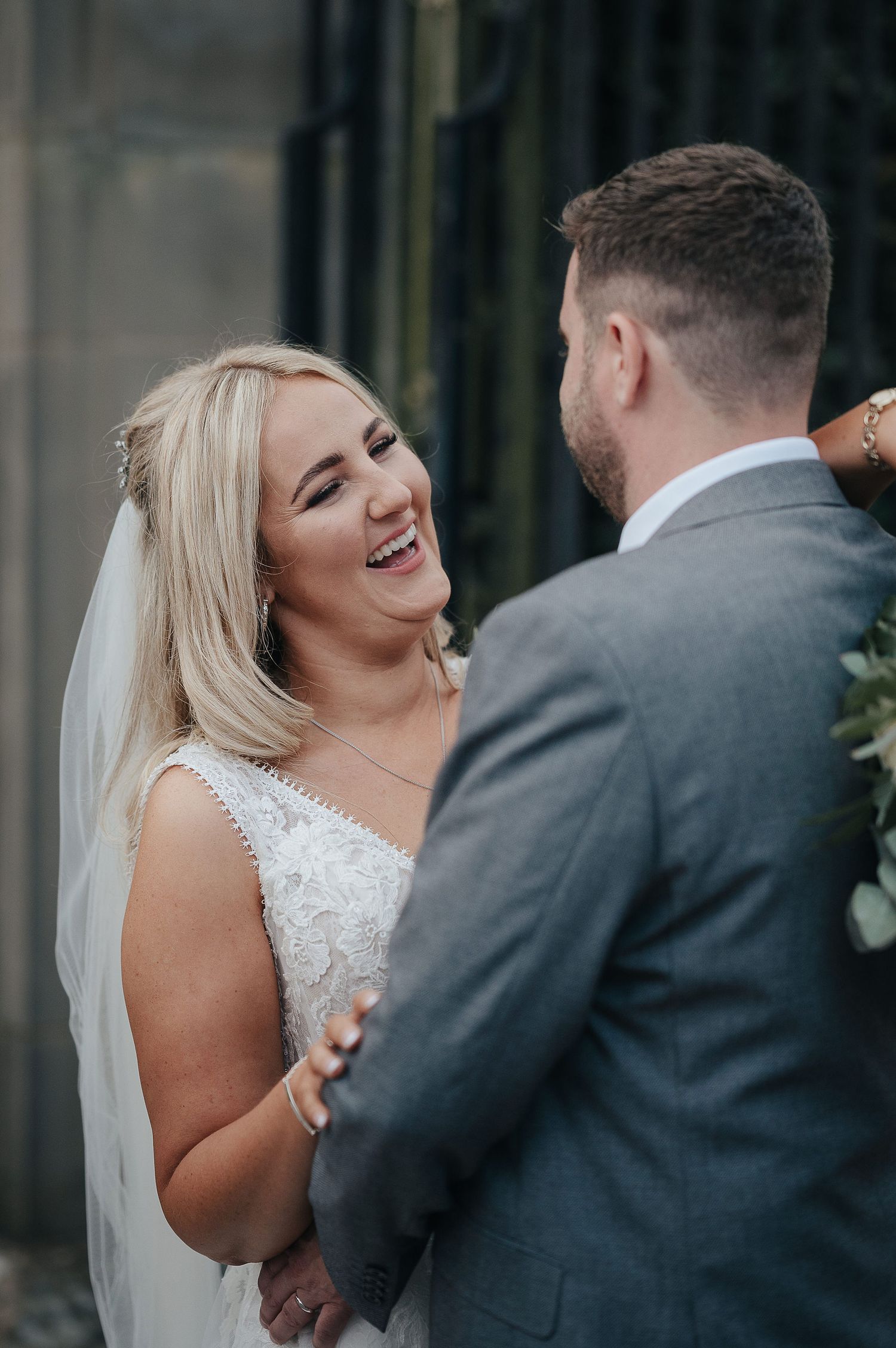 A candid moment between newlyweds sharing laughter during their wedding celebration.