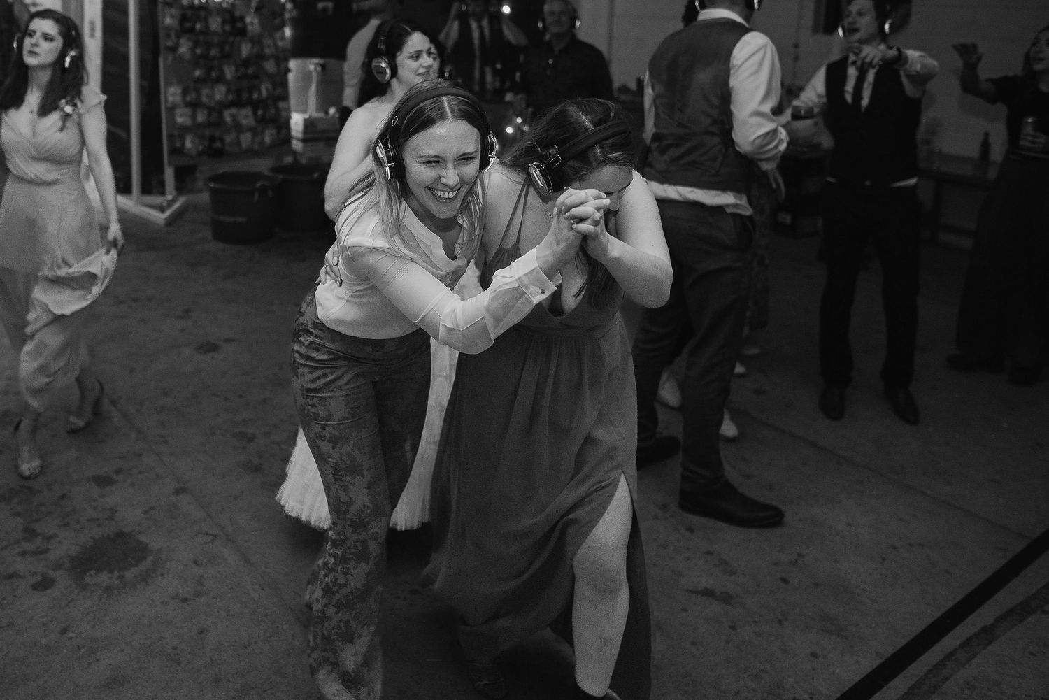 Wedding guests dance and celebrate energetically on the reception dance floor.