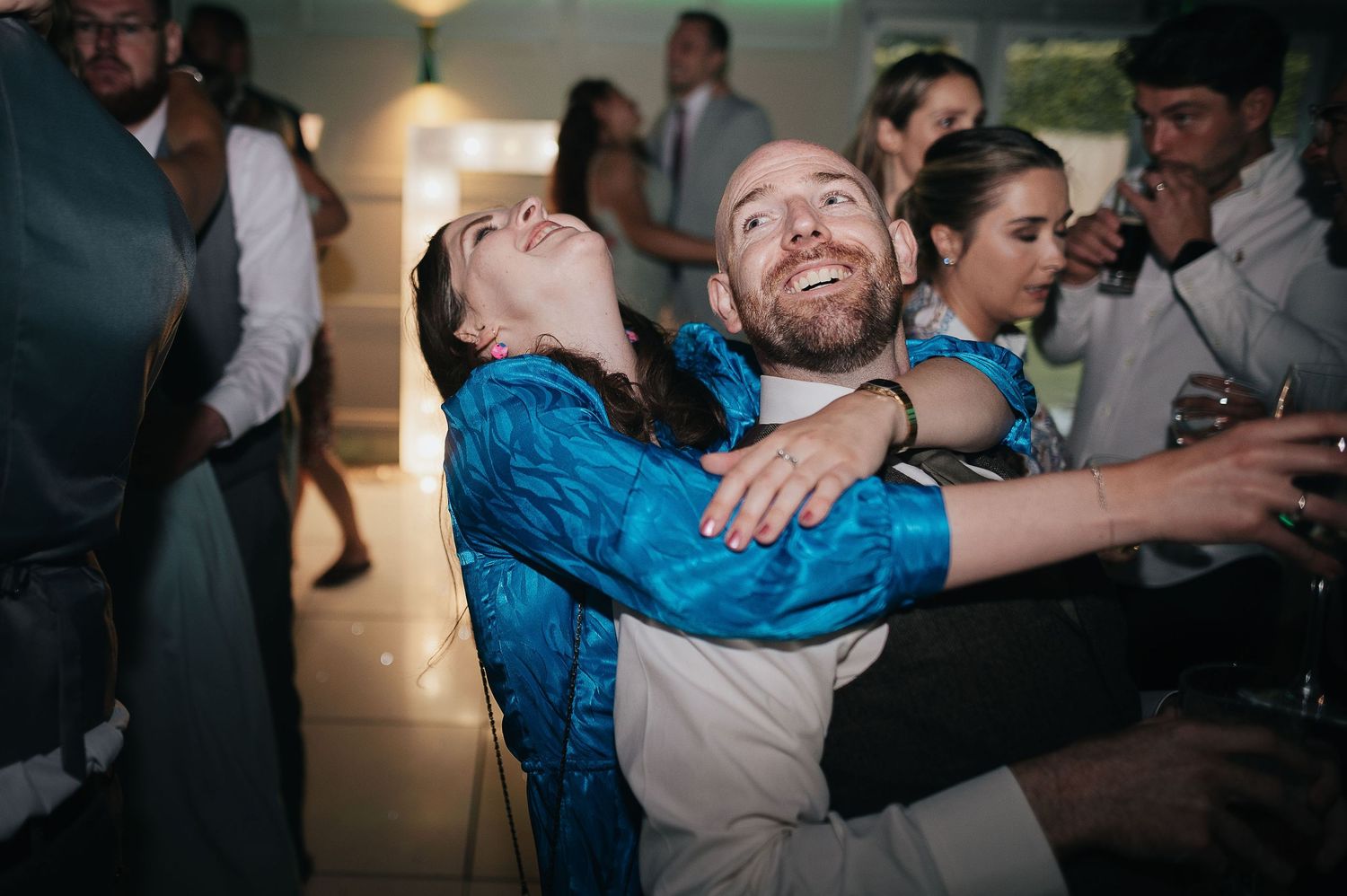 Energetic dancing and celebration captured during wedding reception party.