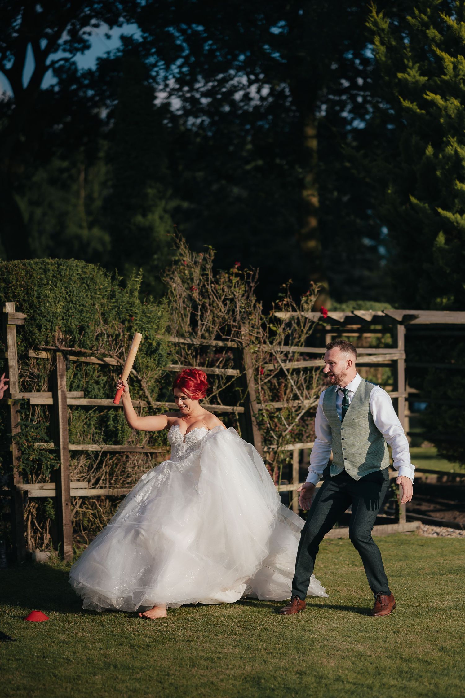 A couple plays a fun lawn game together at their garden wedding.