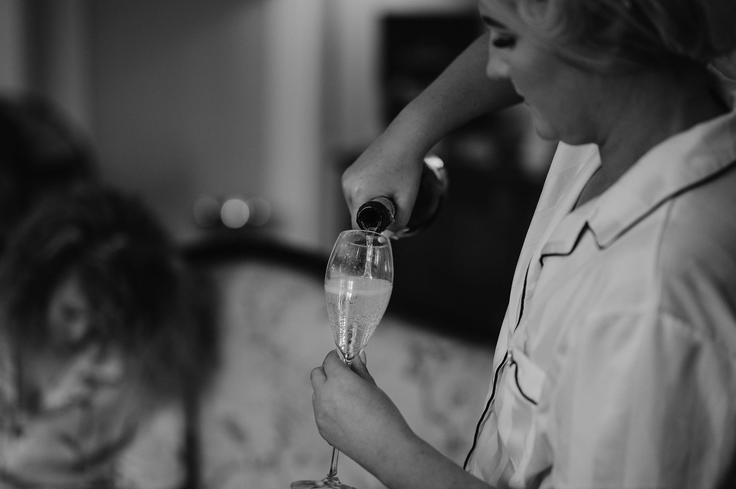 Black and white photo of champagne being poured into a glass.