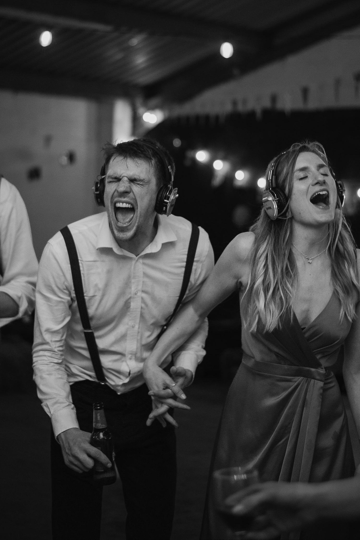 Wedding guests singing with headphones during a silent disco party.