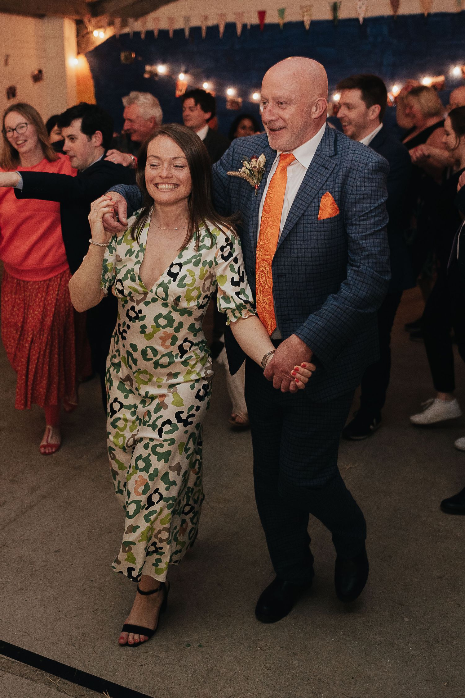 Couples dancing and enjoying themselves at a lively wedding reception.