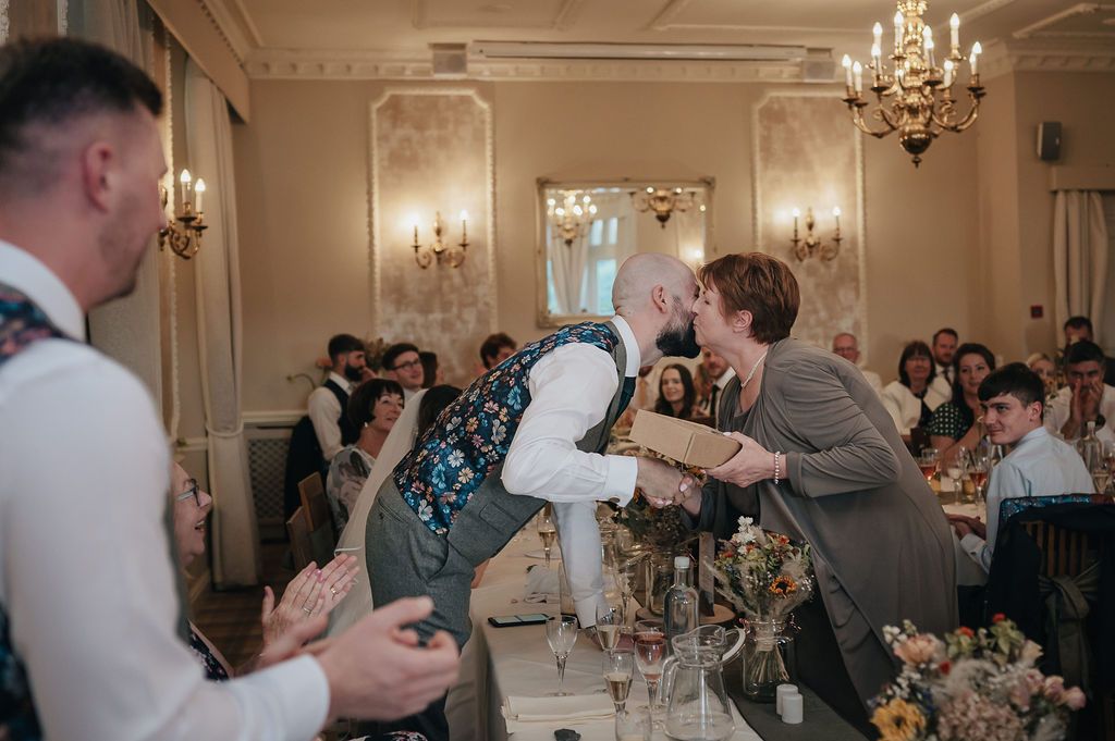 Wedding reception celebration with energetic dancing and entertainment in an elegant ballroom setting.