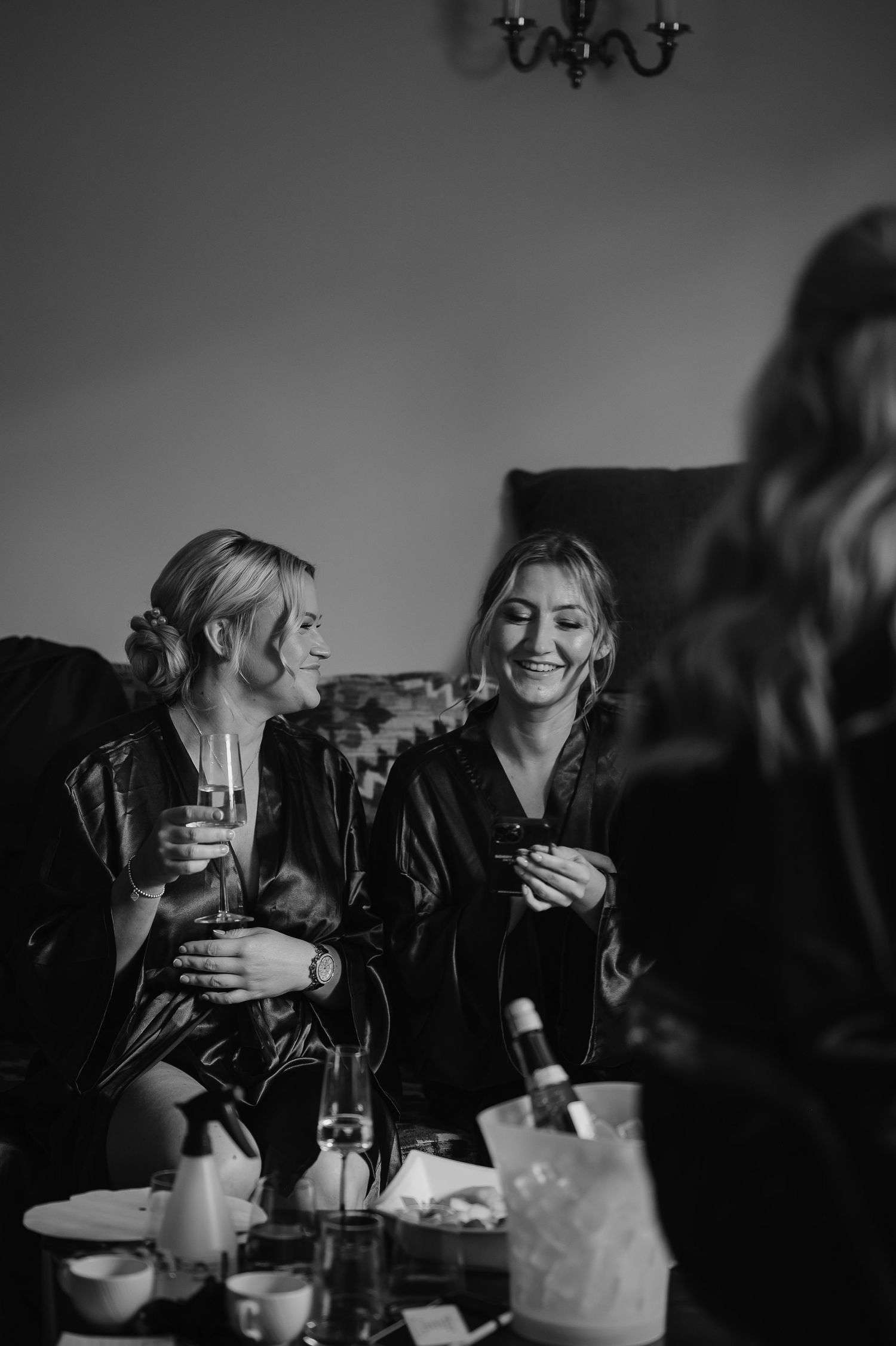 Black and white photo of wedding preparation gathering in an elegant room.