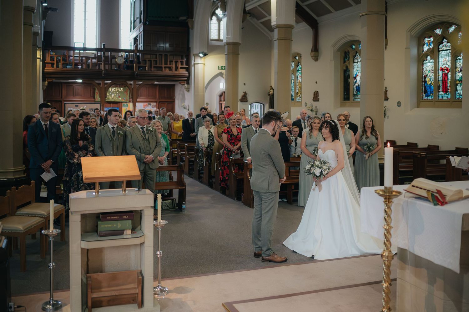 A wedding celebration in a church with guests standing and celebrating the newlyweds.