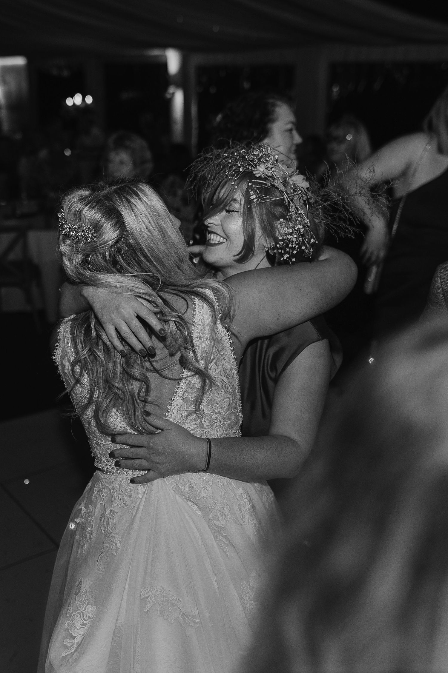 Emotional black and white capture of embrace during wedding reception celebration.