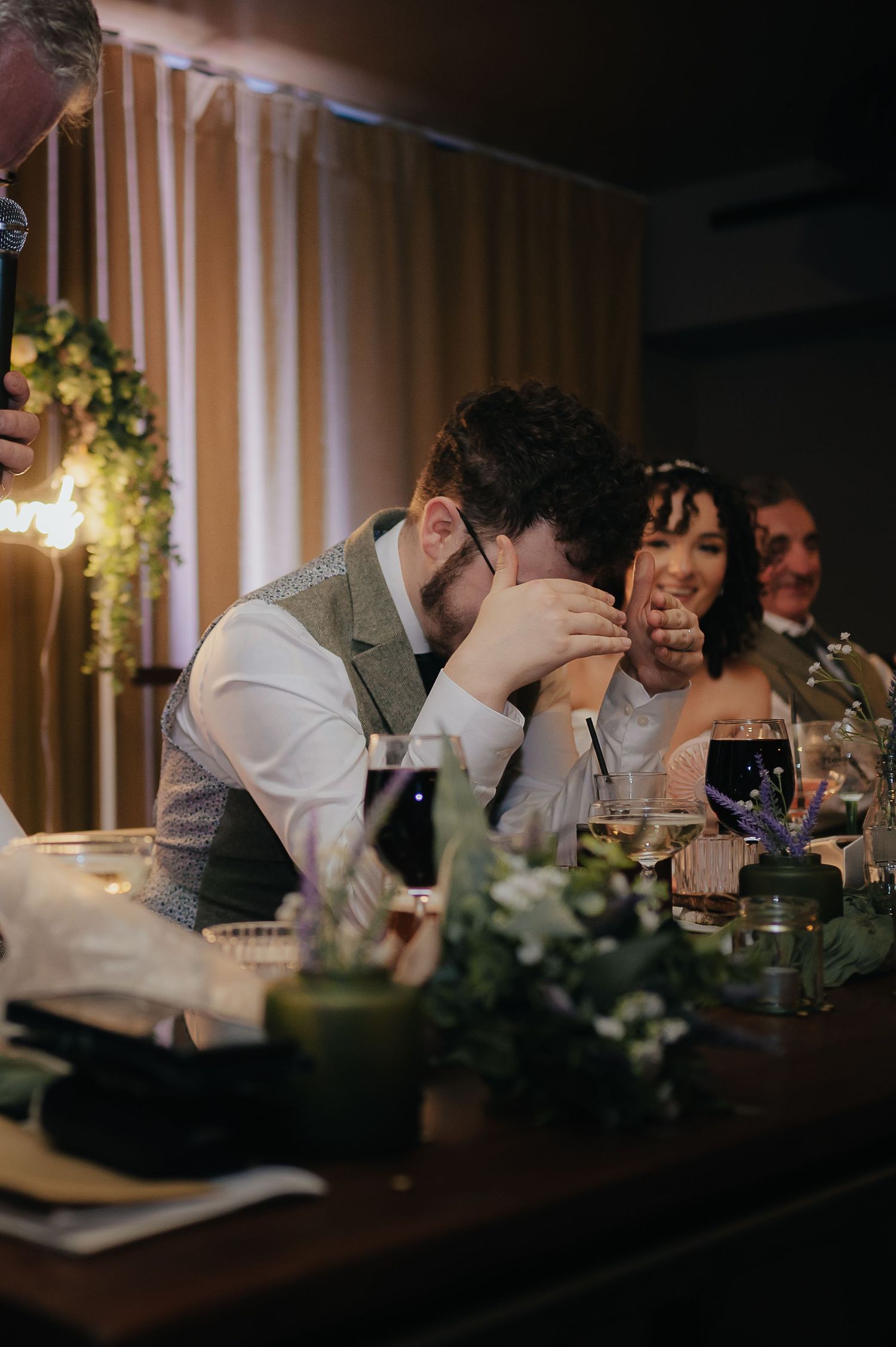 Wedding reception scene with emotional moments captured at a decorated dinner table.