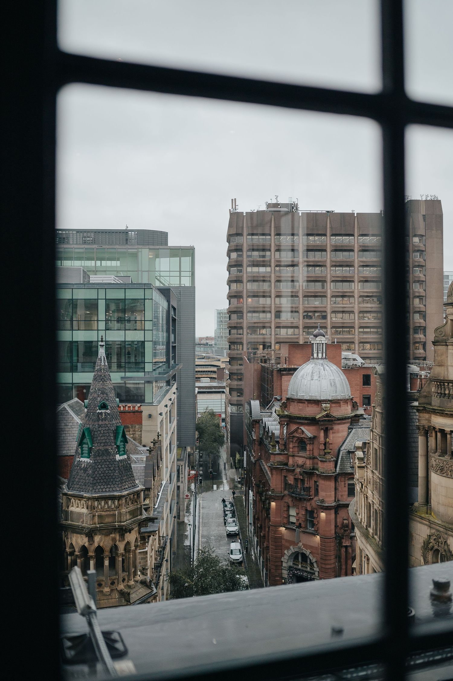 Urban cityscape view through window showing historic architecture in Glasgow.
