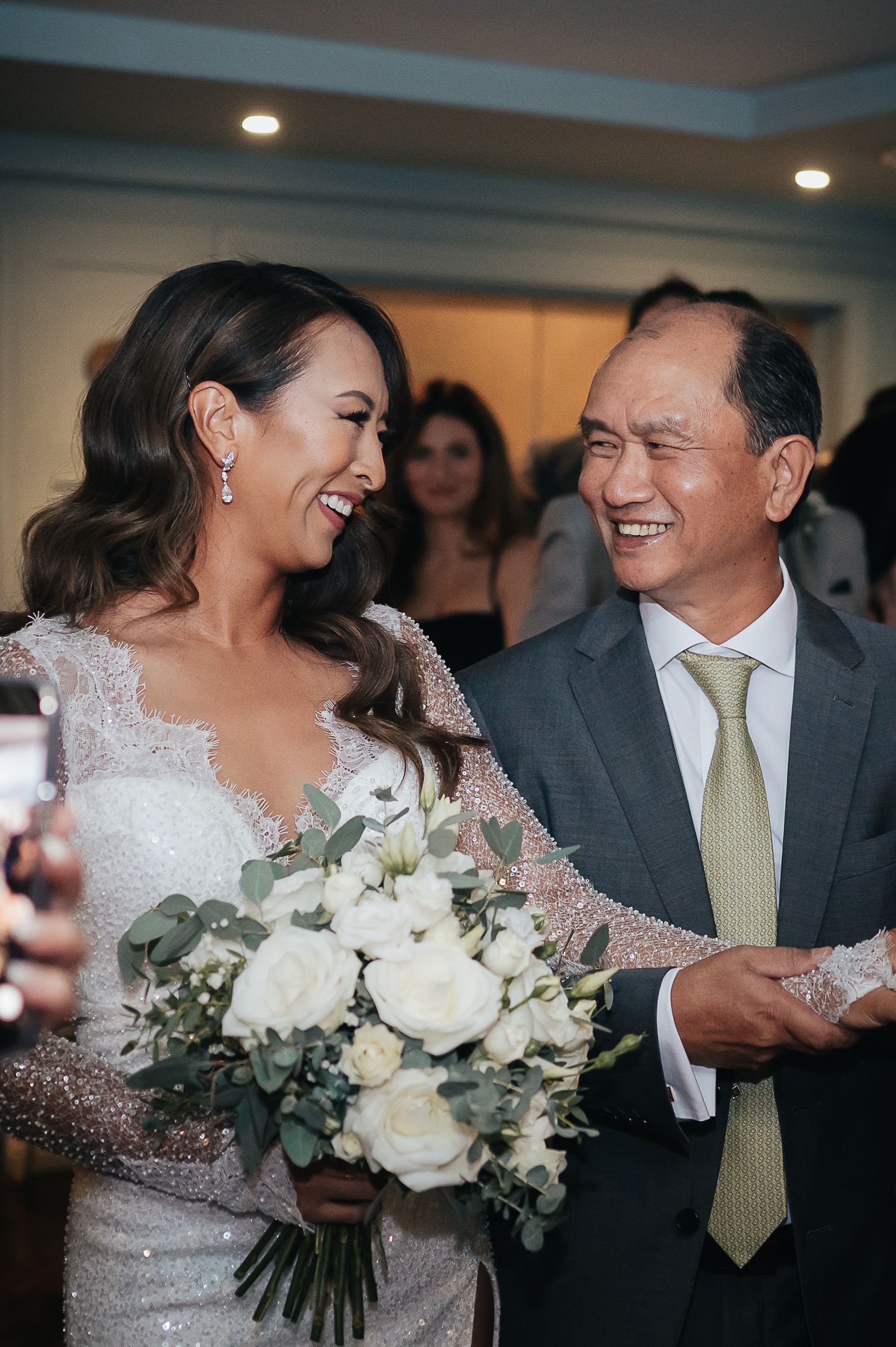 A heartwarming moment with a bride and her guest sharing joyful laughter.