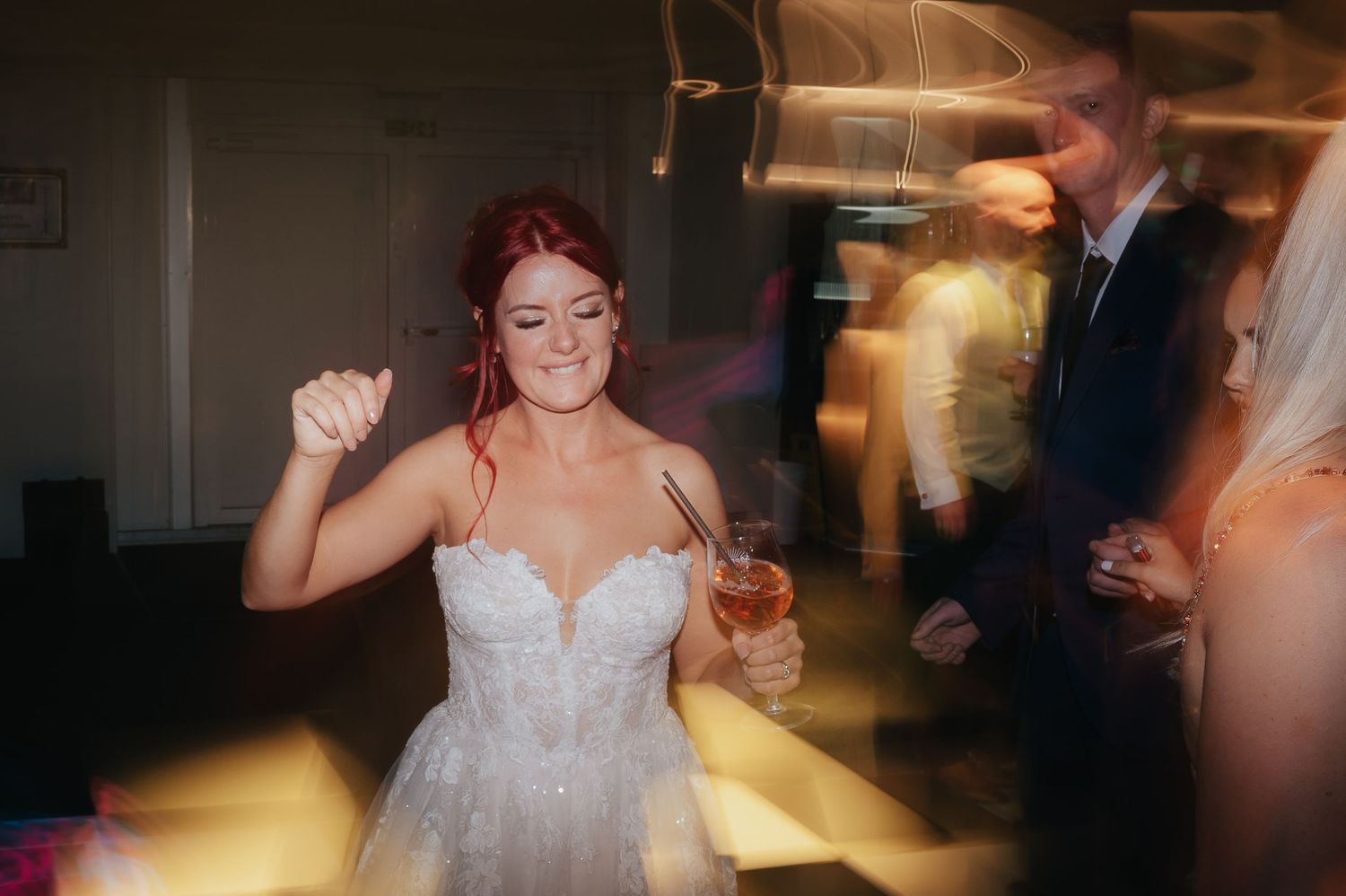 A bride dancing and celebrating at her wedding reception with motion blur effects.